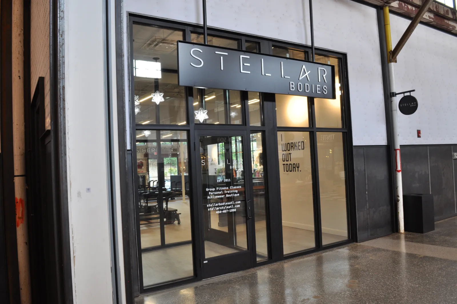 Modern gym storefront with large glass doors and sign reading Stellar Bodies fitness training studio.