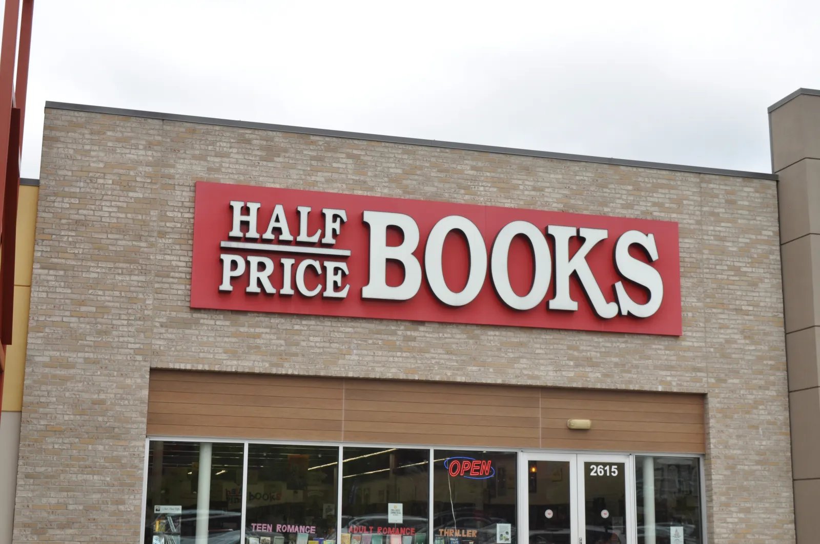 Half Price Books store front with red sign and glass windows showing book sections inside
