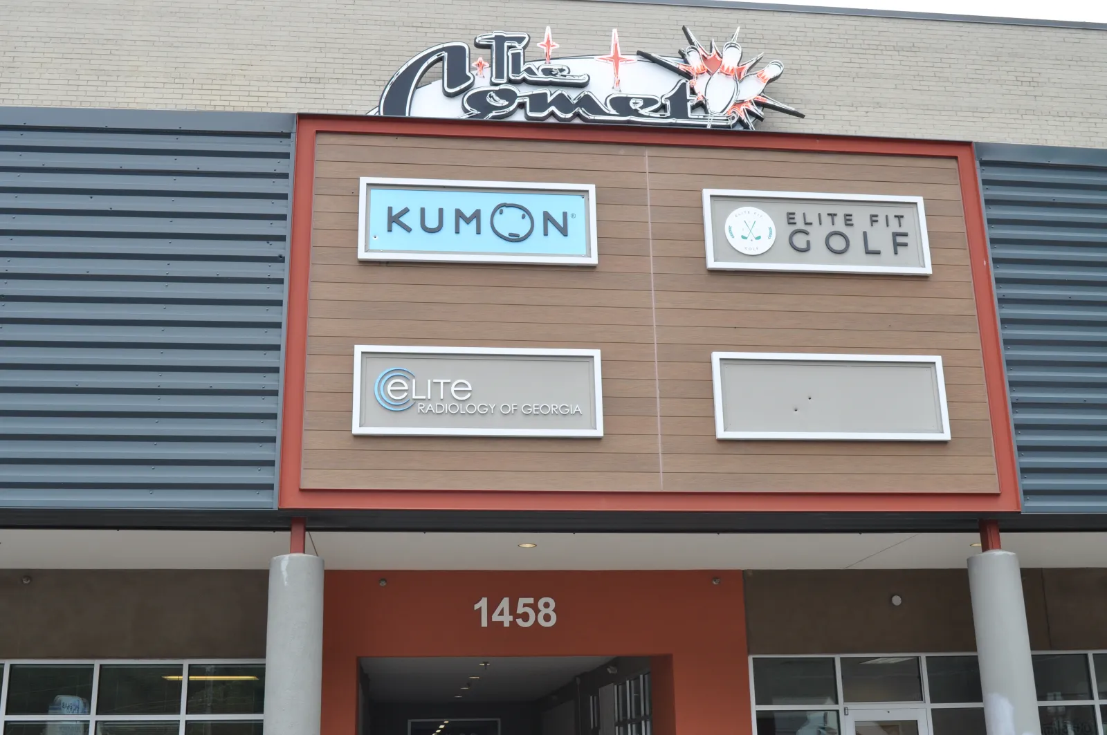 Storefront signs for Kumon, Elite Fit Golf, and Elite Radiology of Georgia on a building facade with address 1458