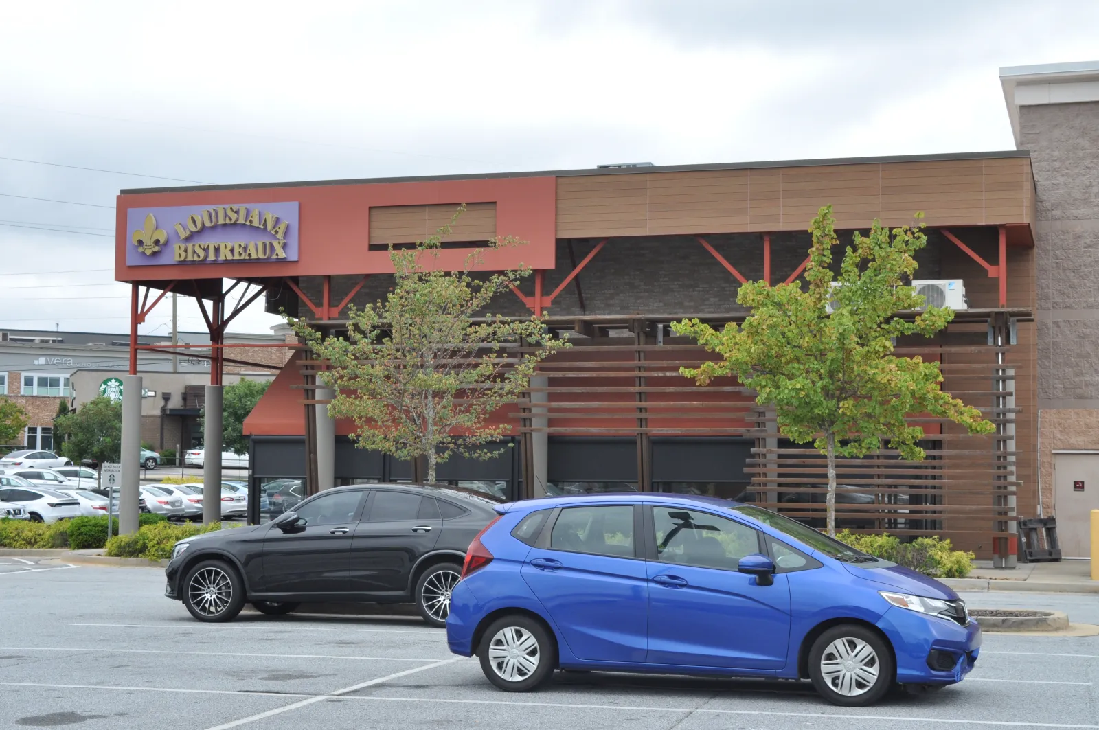 Louisiana Bistreaux restaurant exterior with parked cars in front on a cloudy day.
