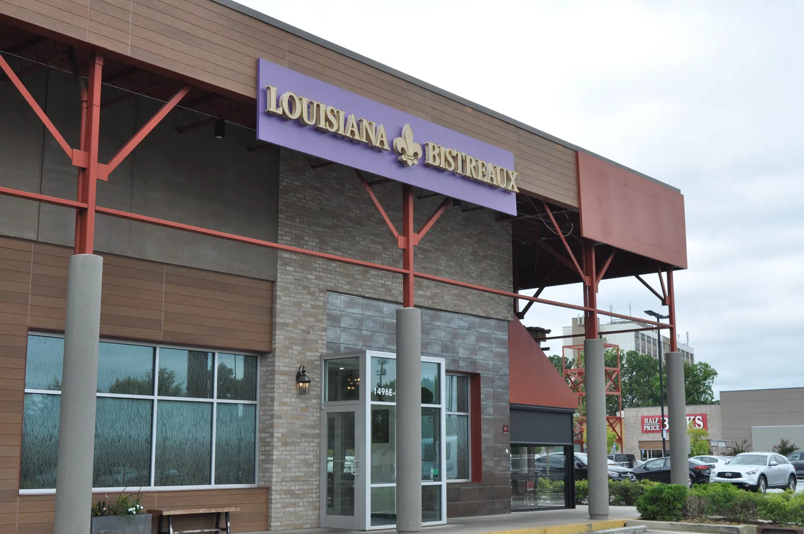 Exterior view of Louisiana Bistreaux restaurant with purple sign and modern architectural design.