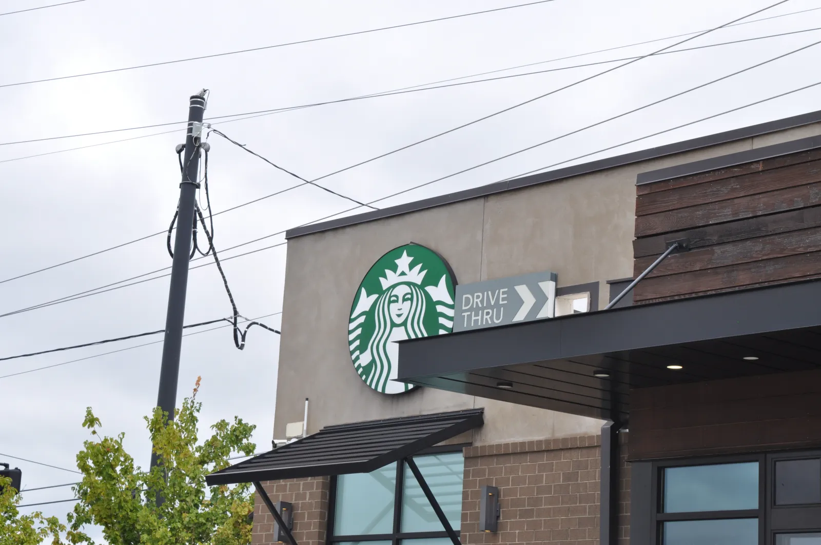 Starbucks coffee shop exterior with drive-thru sign on a cloudy day