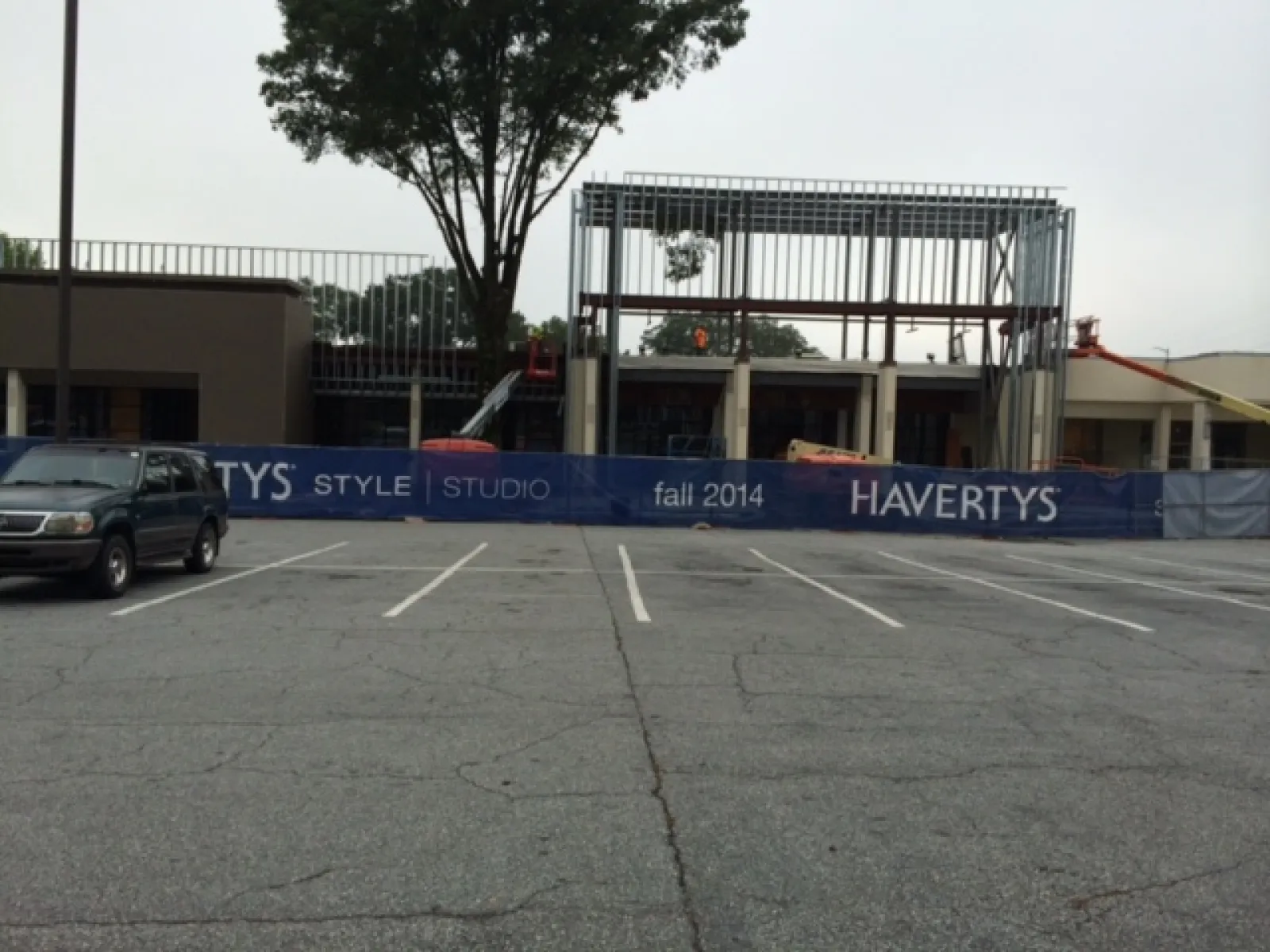Construction site with steel framework and Havertys banner advertising Style Studio fall 2014 near empty parking lot.