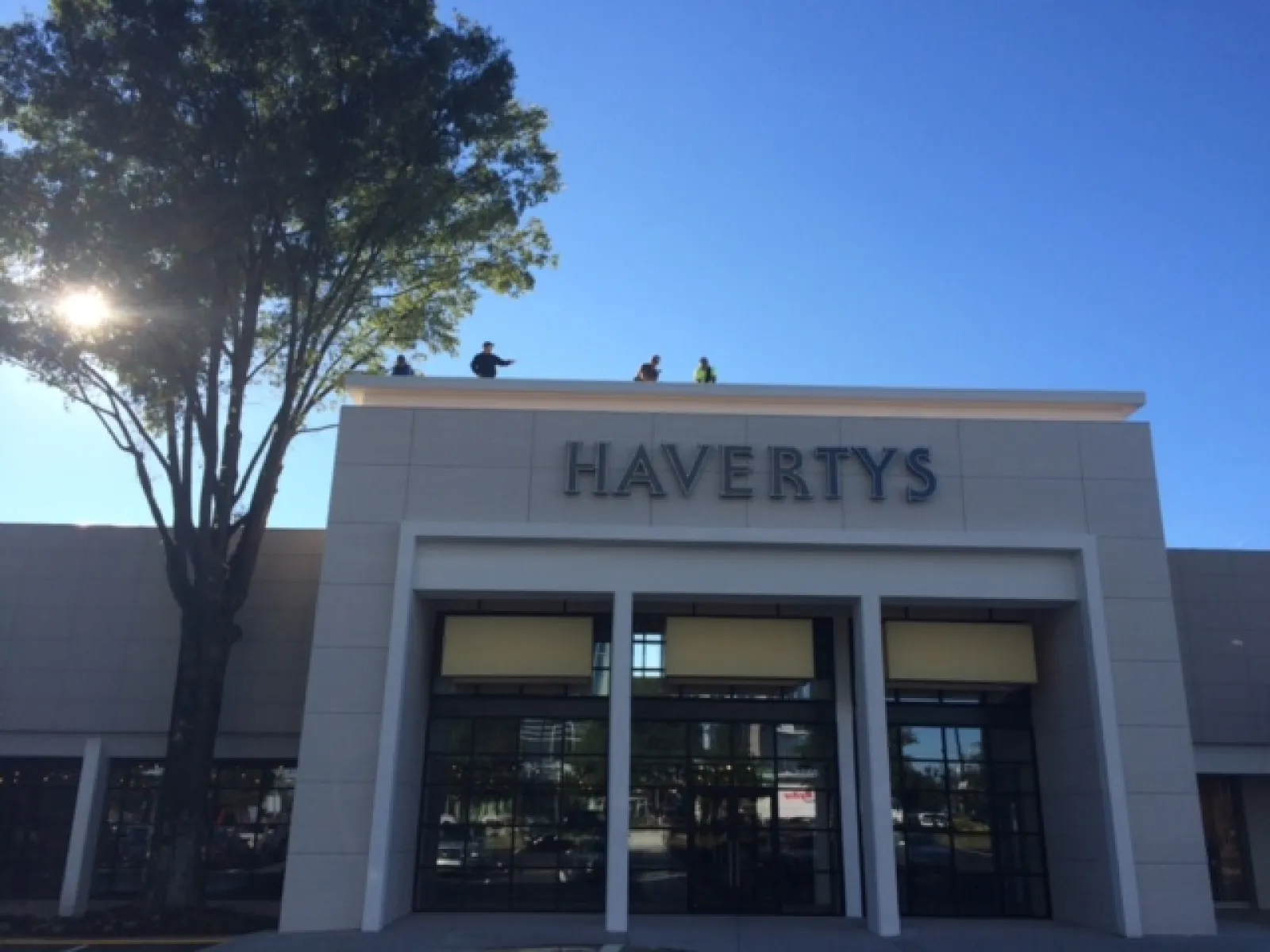 Havertys furniture store exterior with clear blue sky and large tree on the left side.