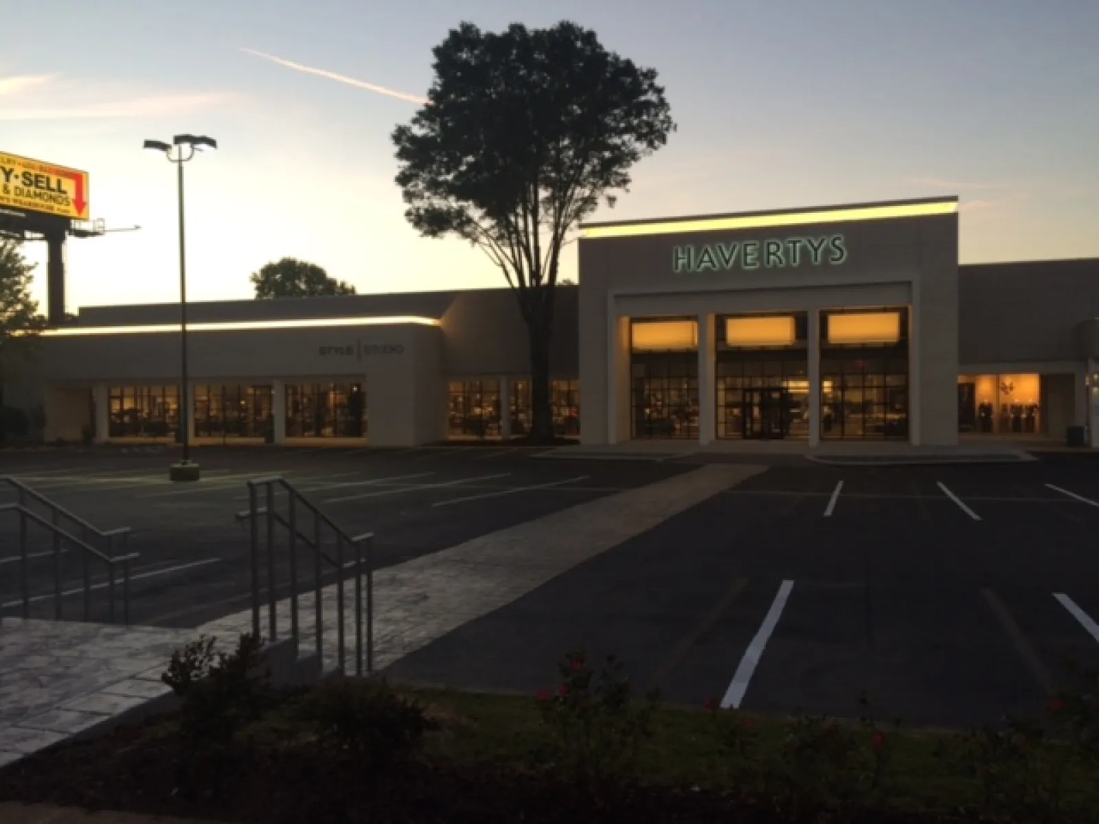 Havertys furniture store at dusk with illuminated signage and empty parking lot in front.