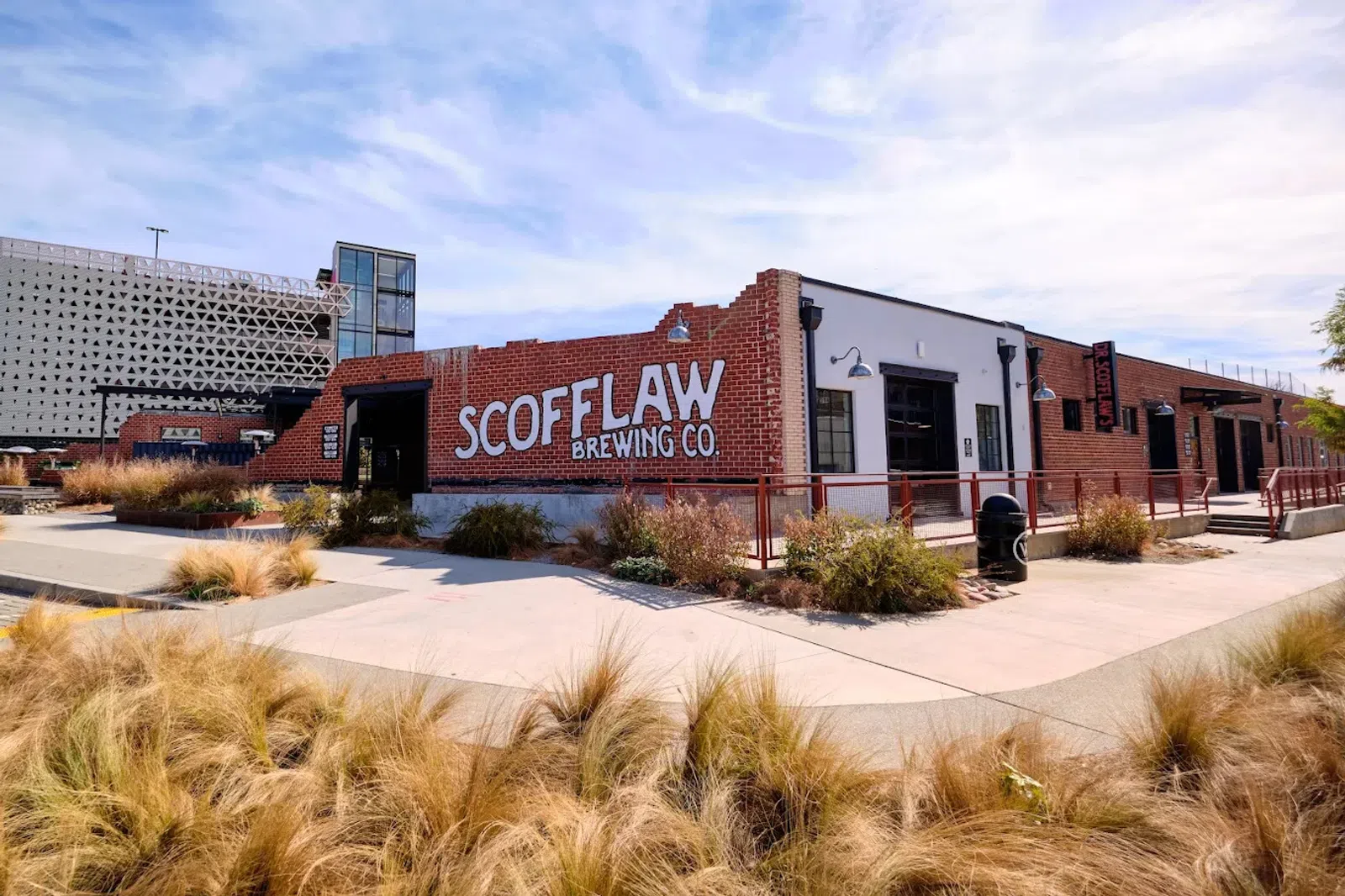 Scofflaw Brewing Co. brick building with outdoor landscaping and clear sky in an urban setting.