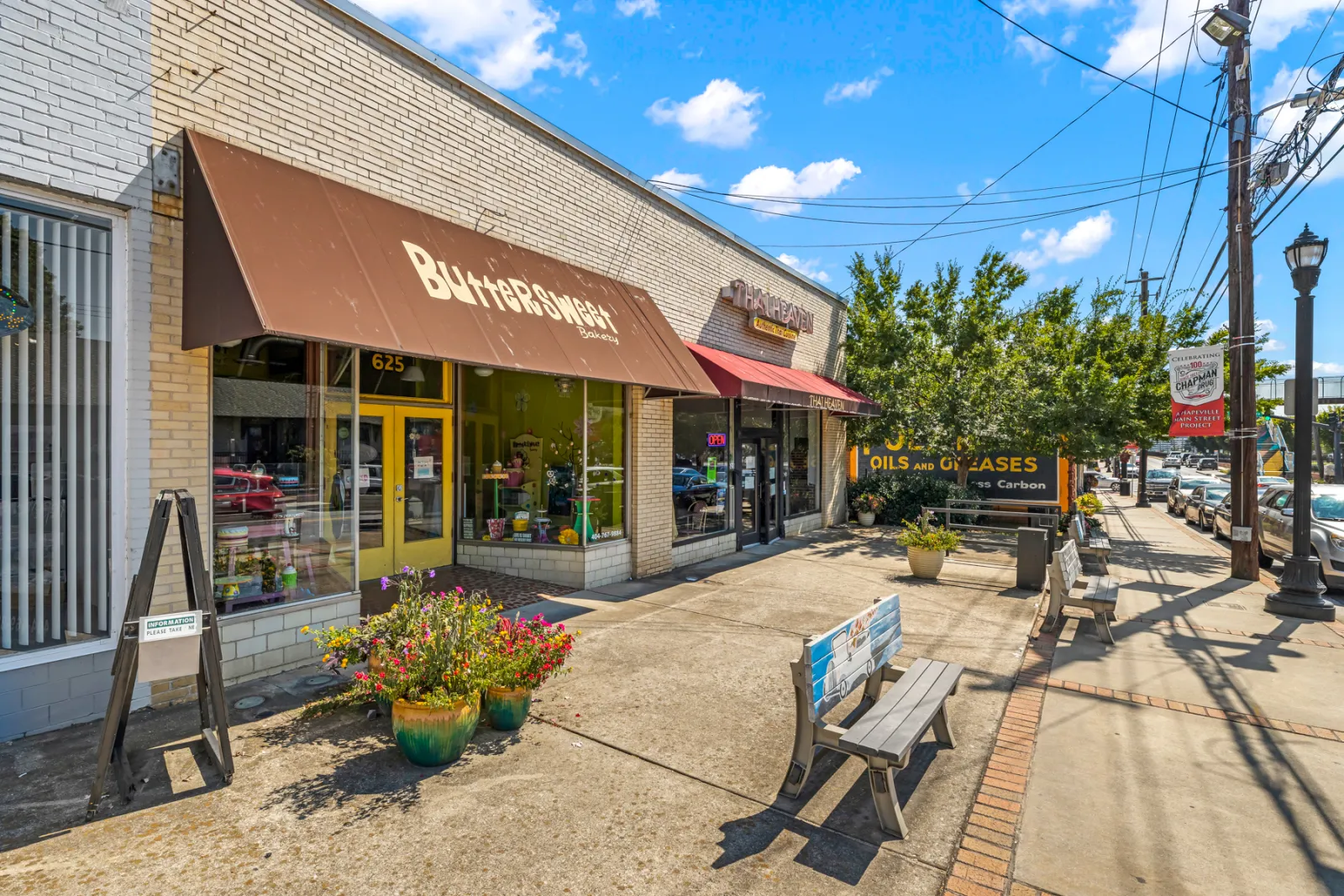 a sidewalk with a bench and a storefront