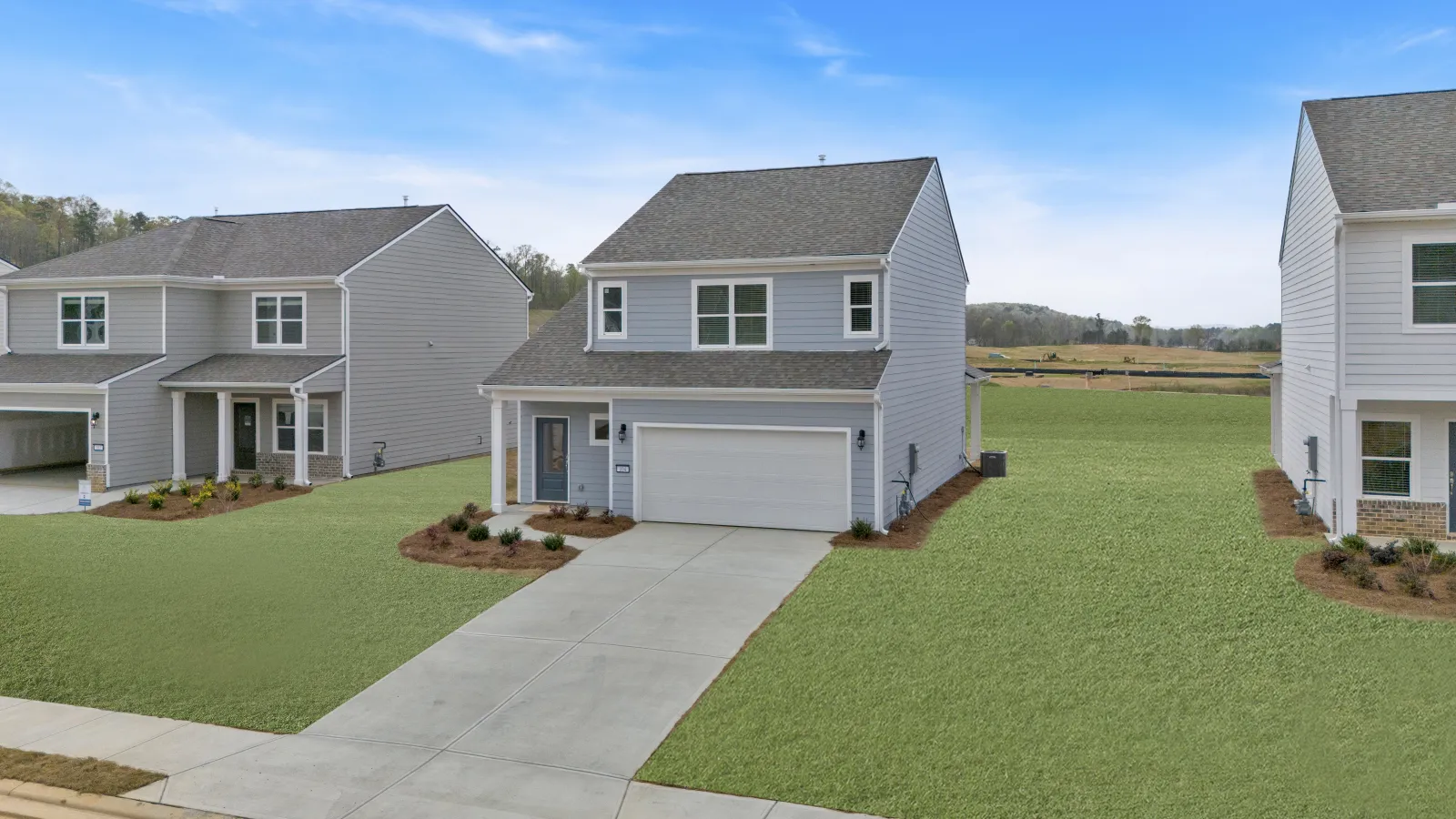 A modern two-story home with a well-maintained lawn and driveway in a suburban neighborhood.
