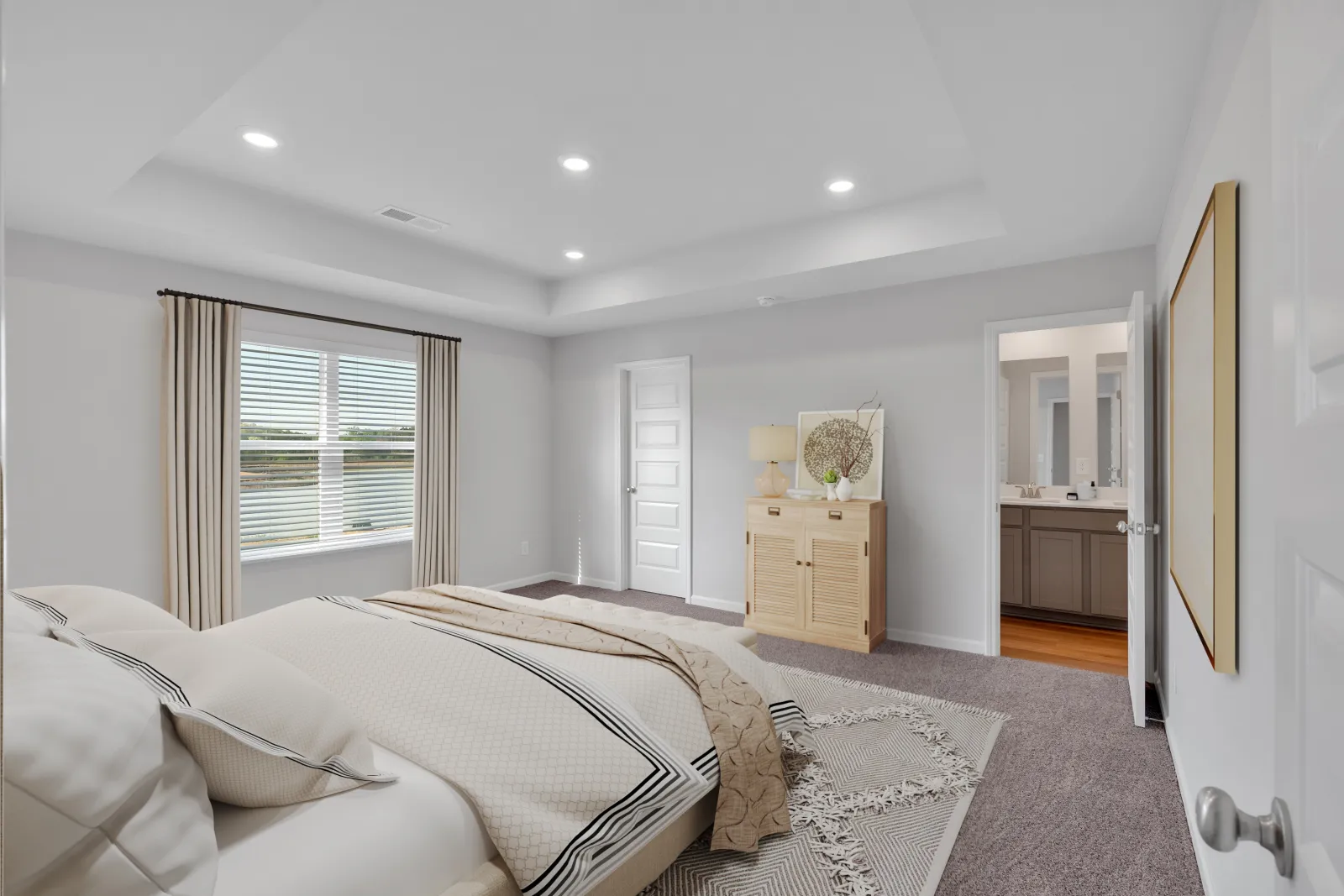 Bright modern bedroom with large bed, beige curtains, wooden dresser, and doorway leading to a bathroom.