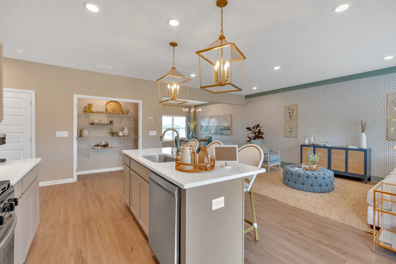 Modern kitchen with island, elegant lighting, and stylish decor in a spacious living area.