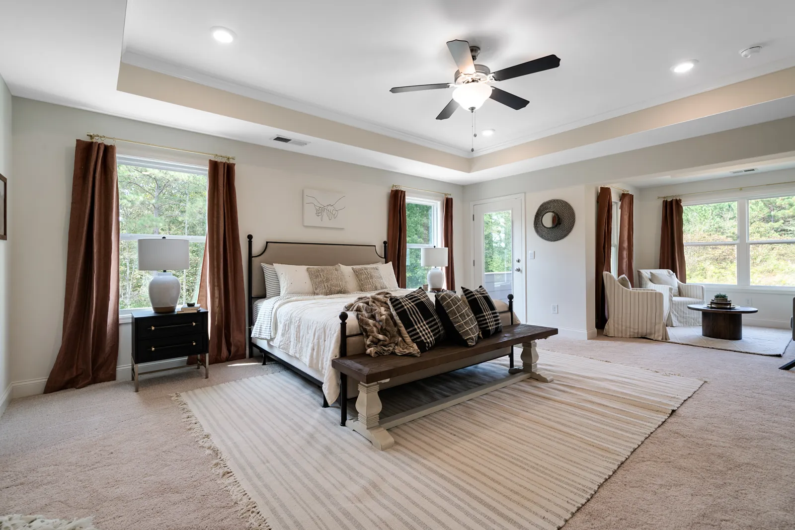 a bedroom with a large bed and a fan