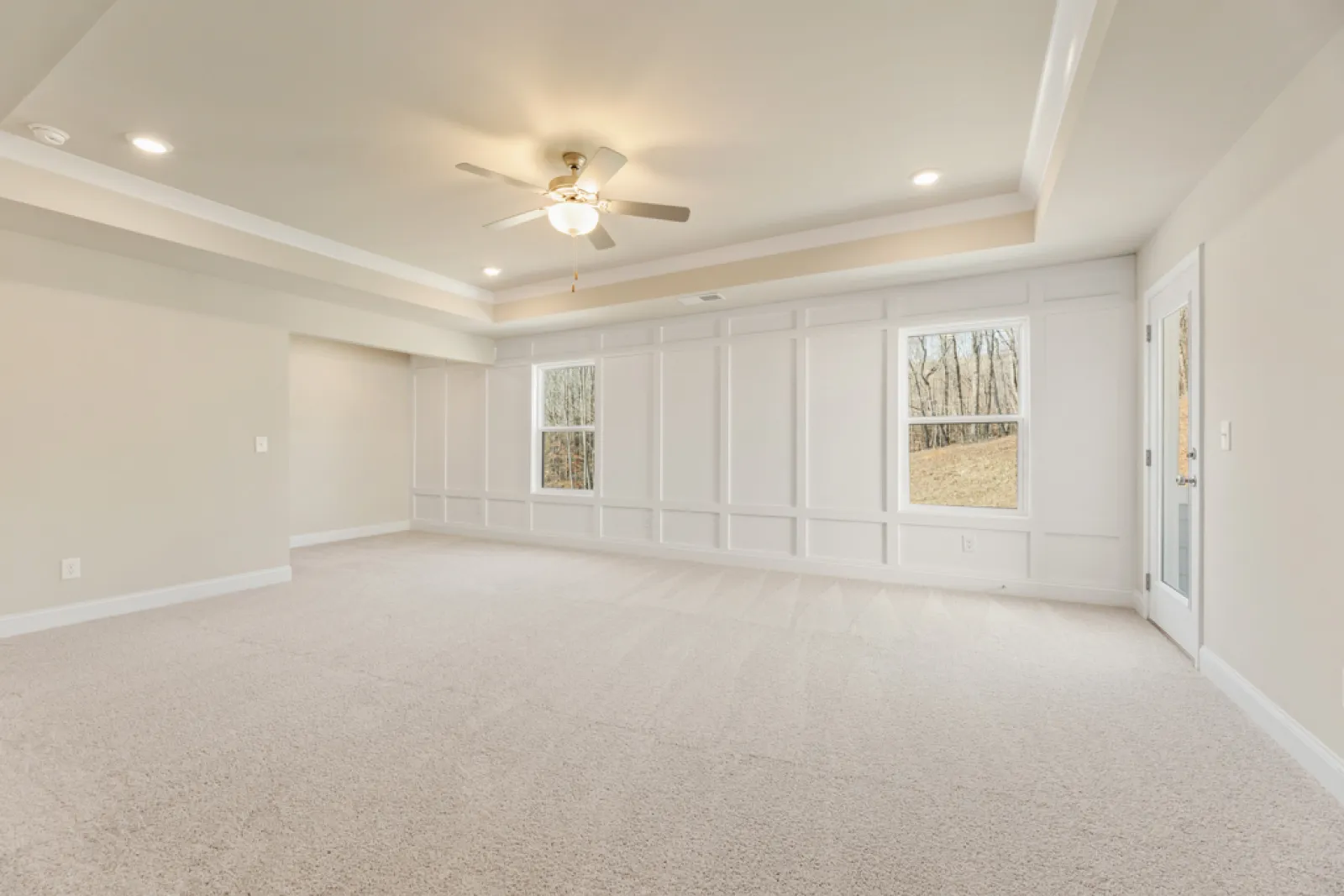 a room with a ceiling fan and white walls