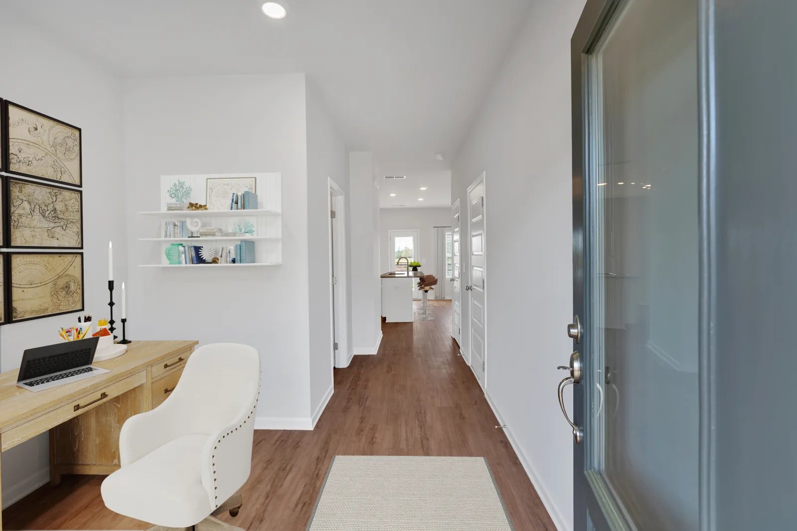 Modern white hallway with wood floors, desk workspace with chair, and open door revealing bright interior.