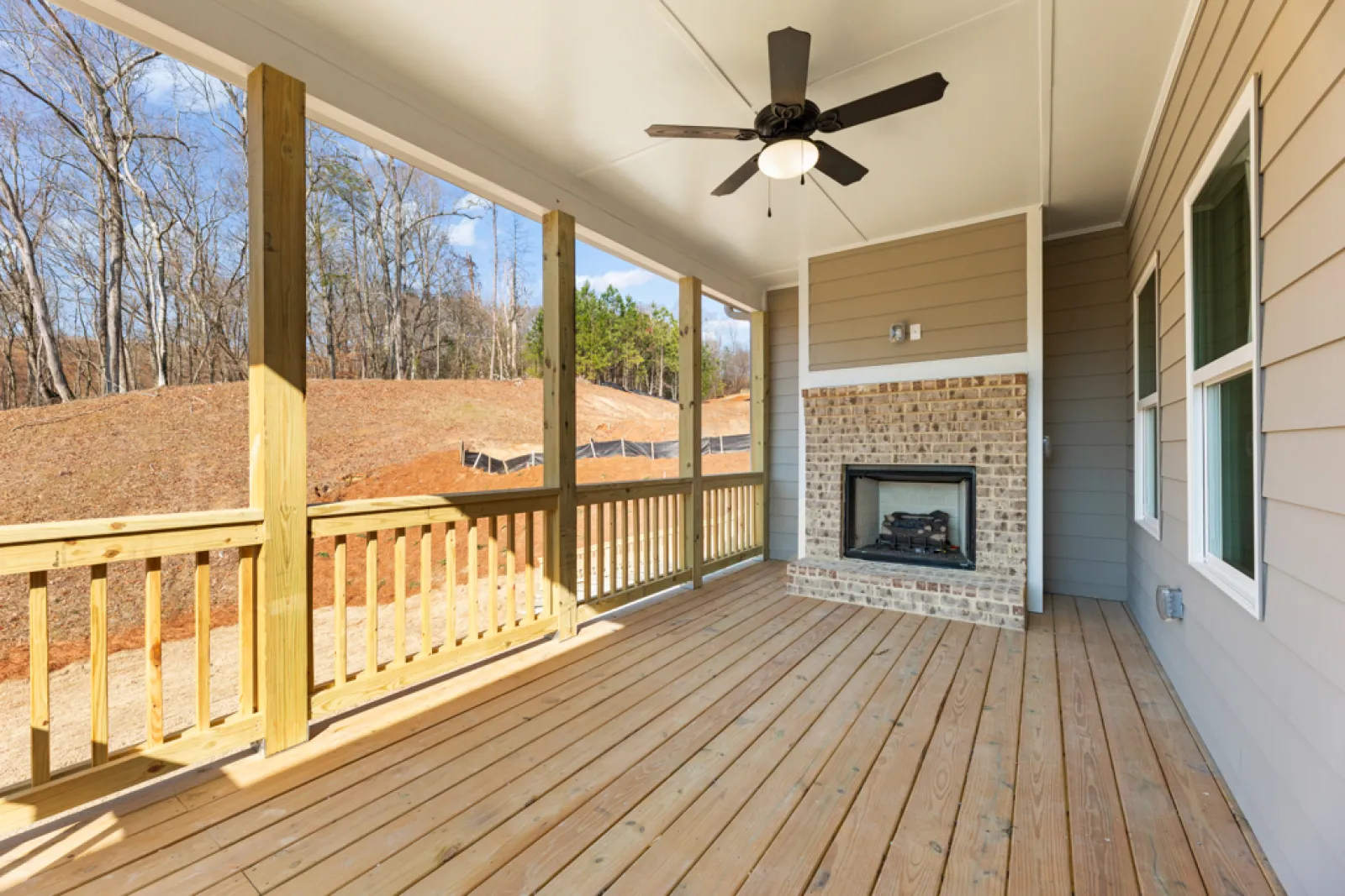 a wood deck with a fireplace and a wood railing with a wood railing