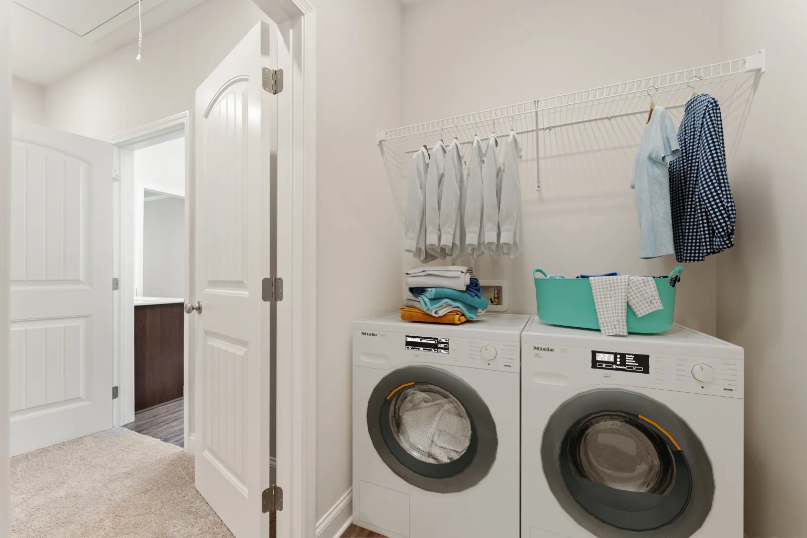 a laundry room with a washing machine and towels on the wall