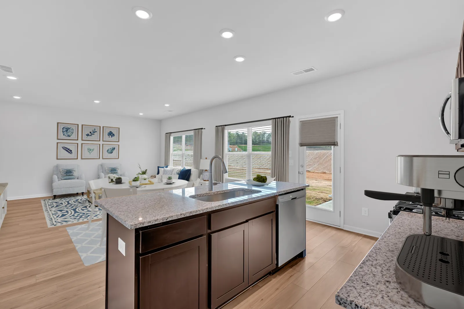 Modern kitchen with a stylish island, natural light, and a cozy living area in a contemporary home.
