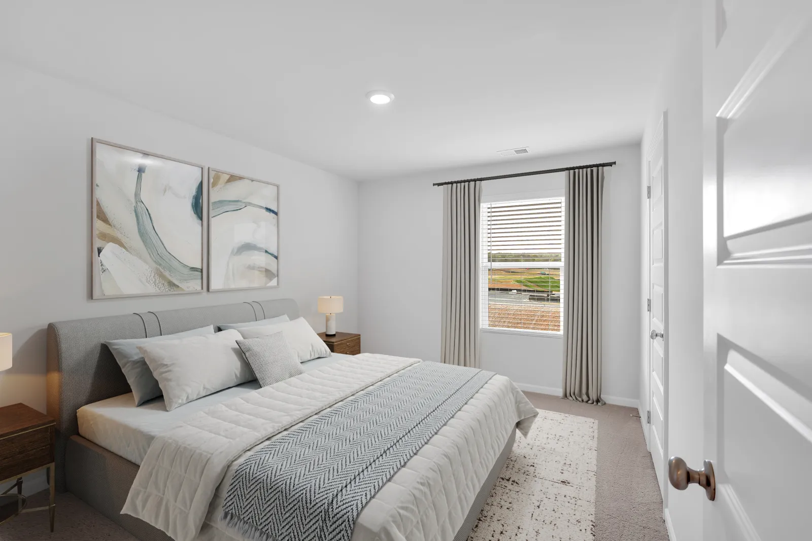 Bright and modern bedroom with soft colors, stylish bedding, and abstract wall art.