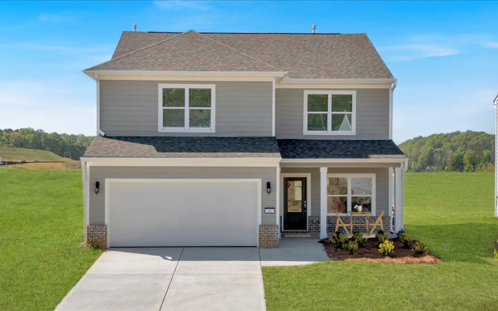 Modern two-story gray house with large garage, porch seating, and a fresh green lawn on a sunny day