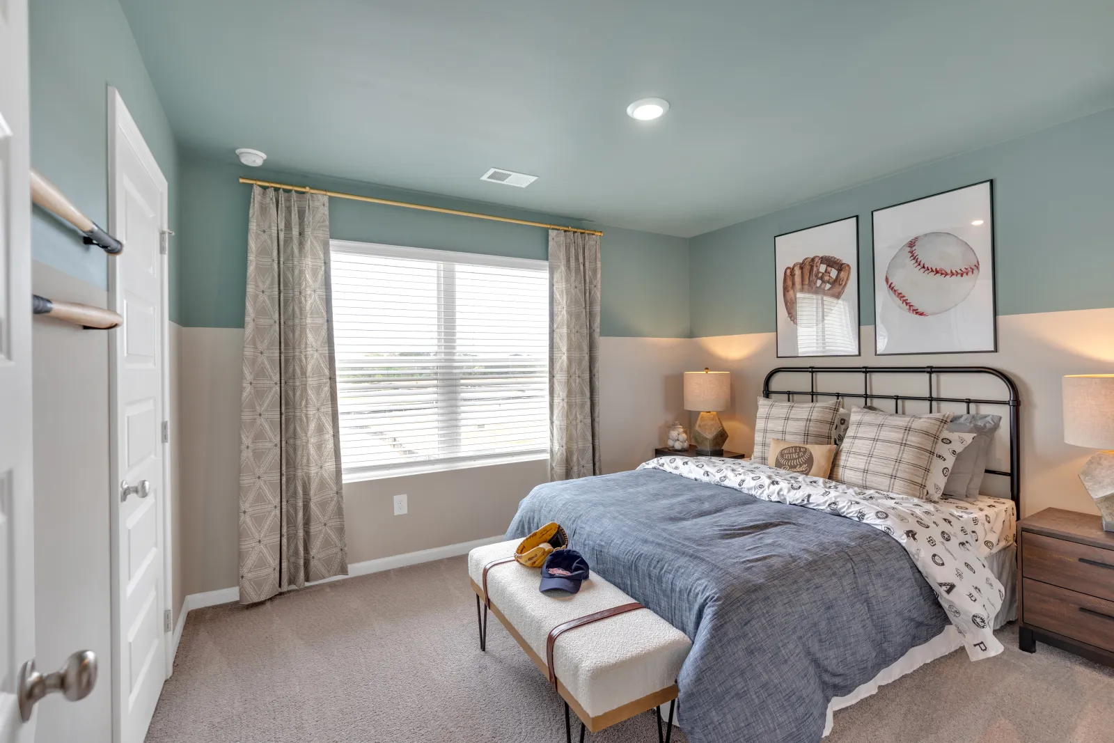 Stylish bedroom featuring blue walls, cozy bedding, and baseball-themed decor.