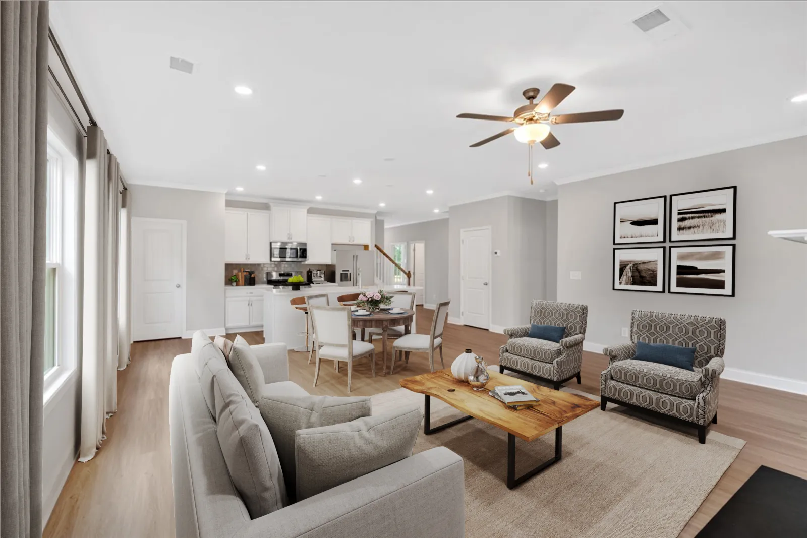 Bright open-concept living room and kitchen with modern furniture, wood floors, and ceiling fan light fixture