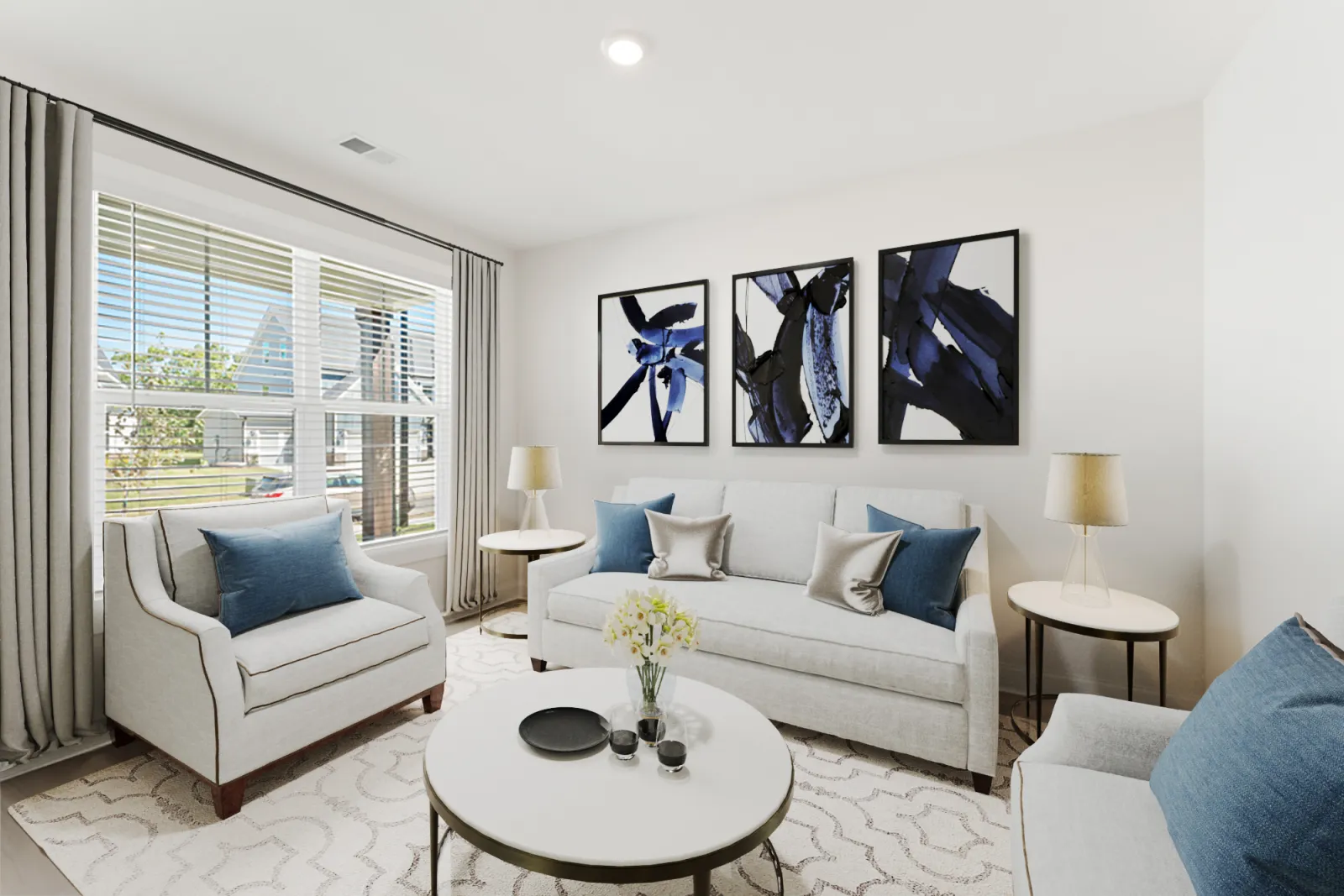 a living room with a white couch and a table with blue pillows