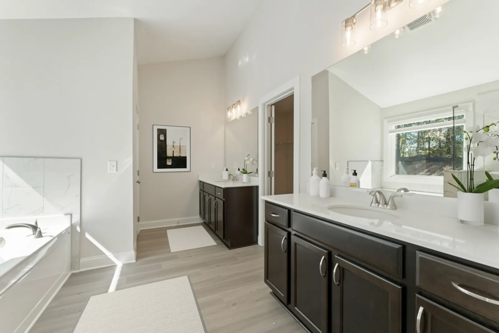 a bathroom with a tub sink and cabinets