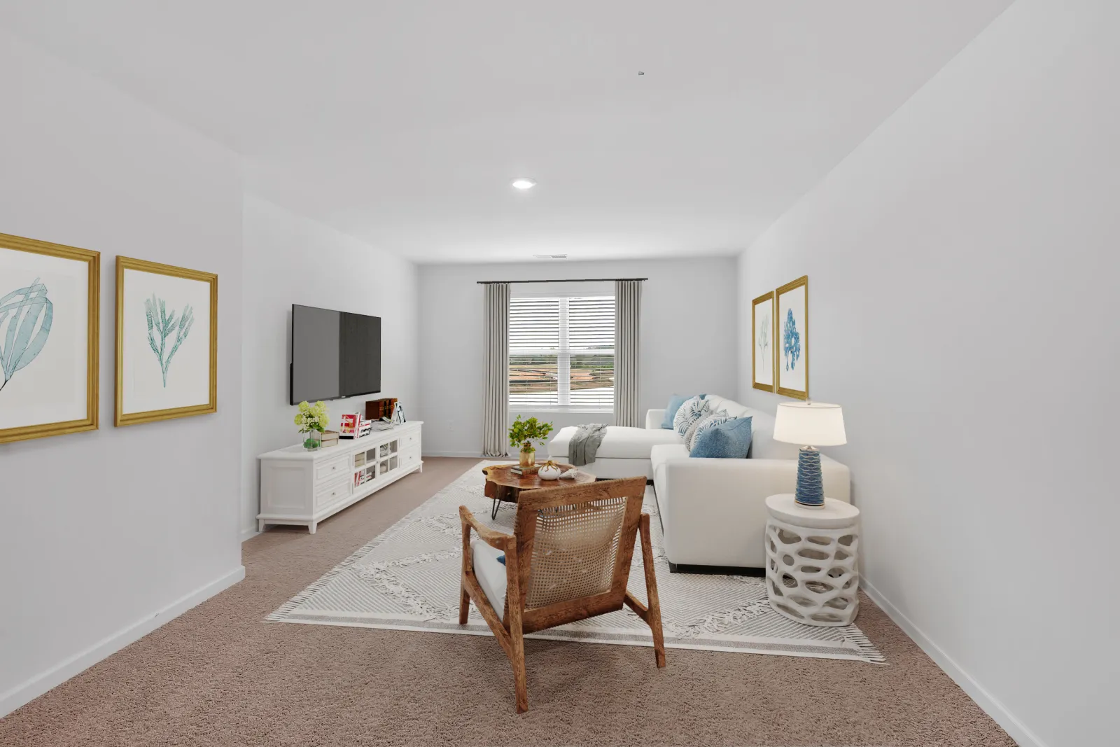 Bright living room with white walls, beige carpet, white sofa, wooden chair and decorative wall art.