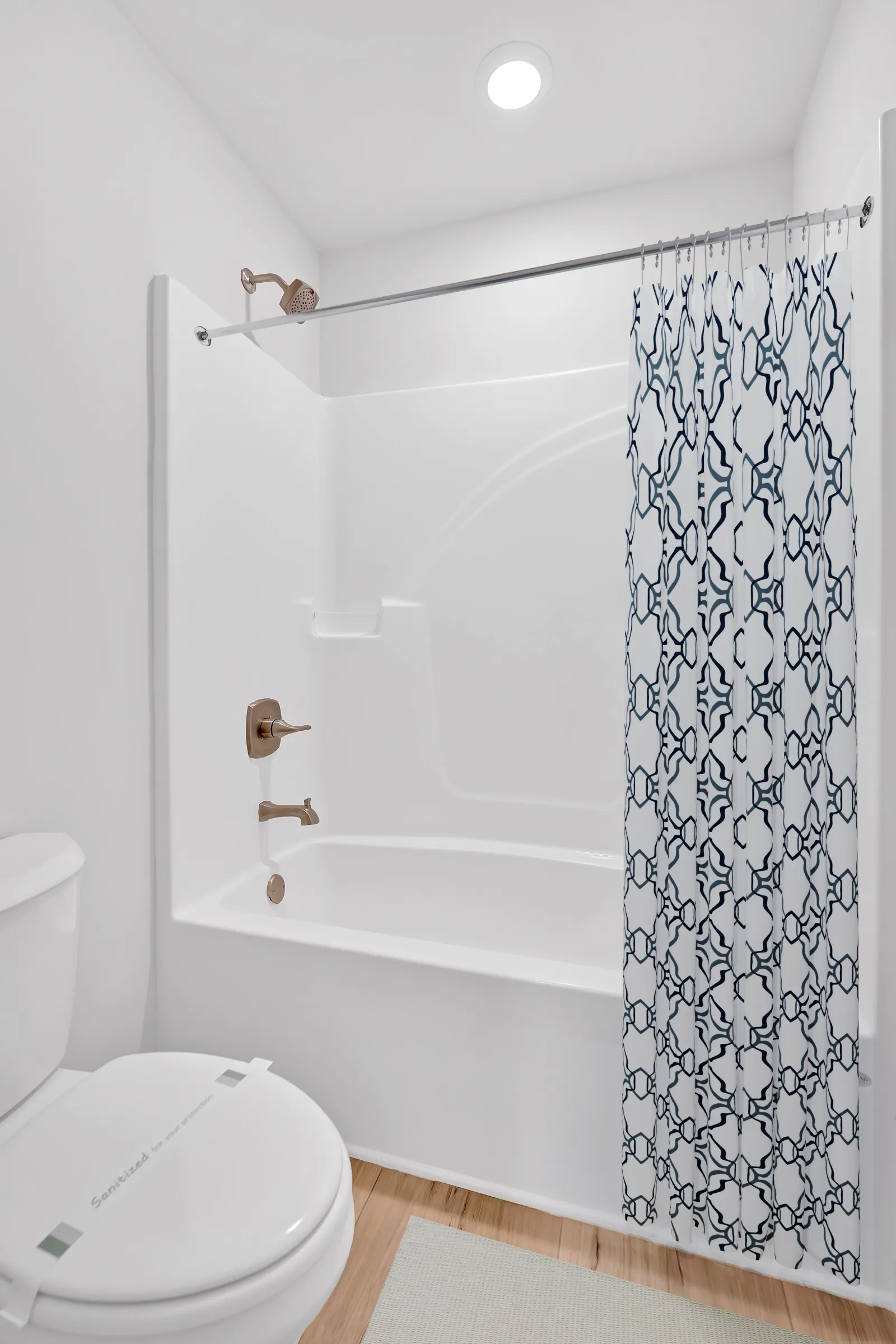 Bright and modern bathroom featuring a white tub, elegant shower curtain, and minimalist design.