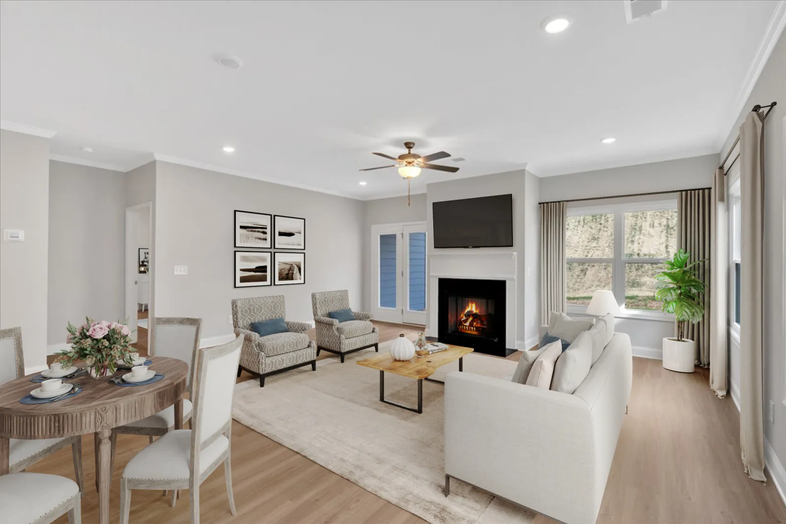 Bright living room with fireplace, ceiling fan, modern furniture, wooden dining table, and large windows with curtains