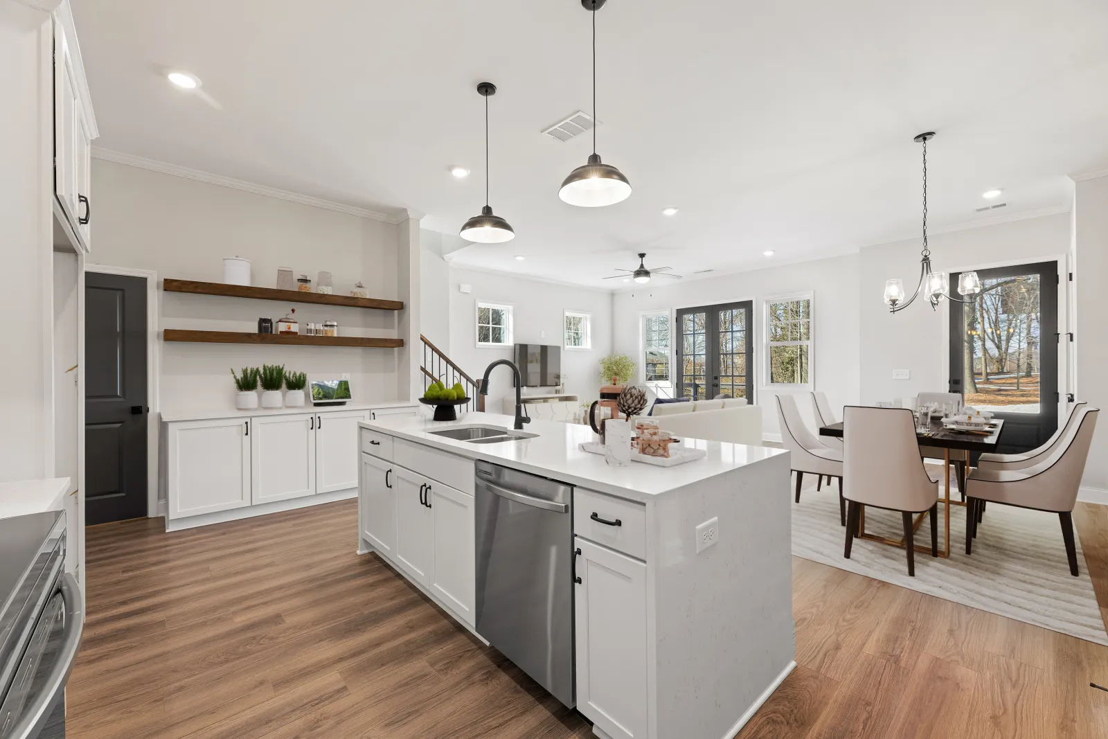Serenity townhome model kitchen with white countertops and white cabinetry and view of dining room