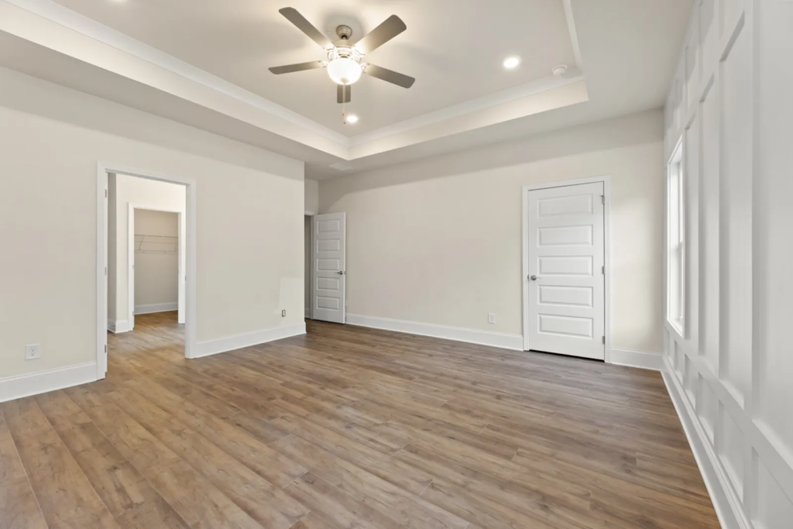 a room with a wood floor and a ceiling fan