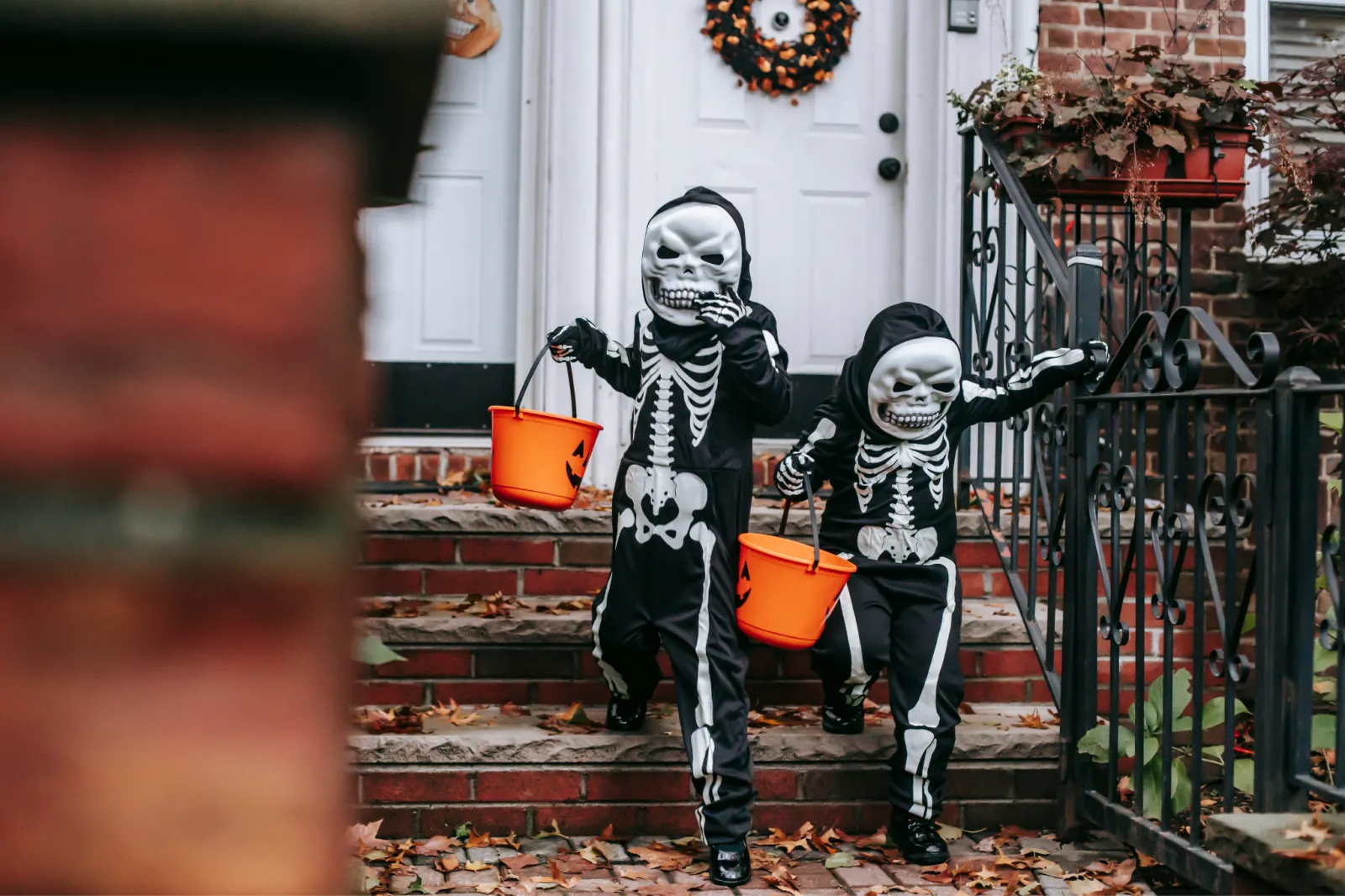 two kids in skeleton costumes trick or treating