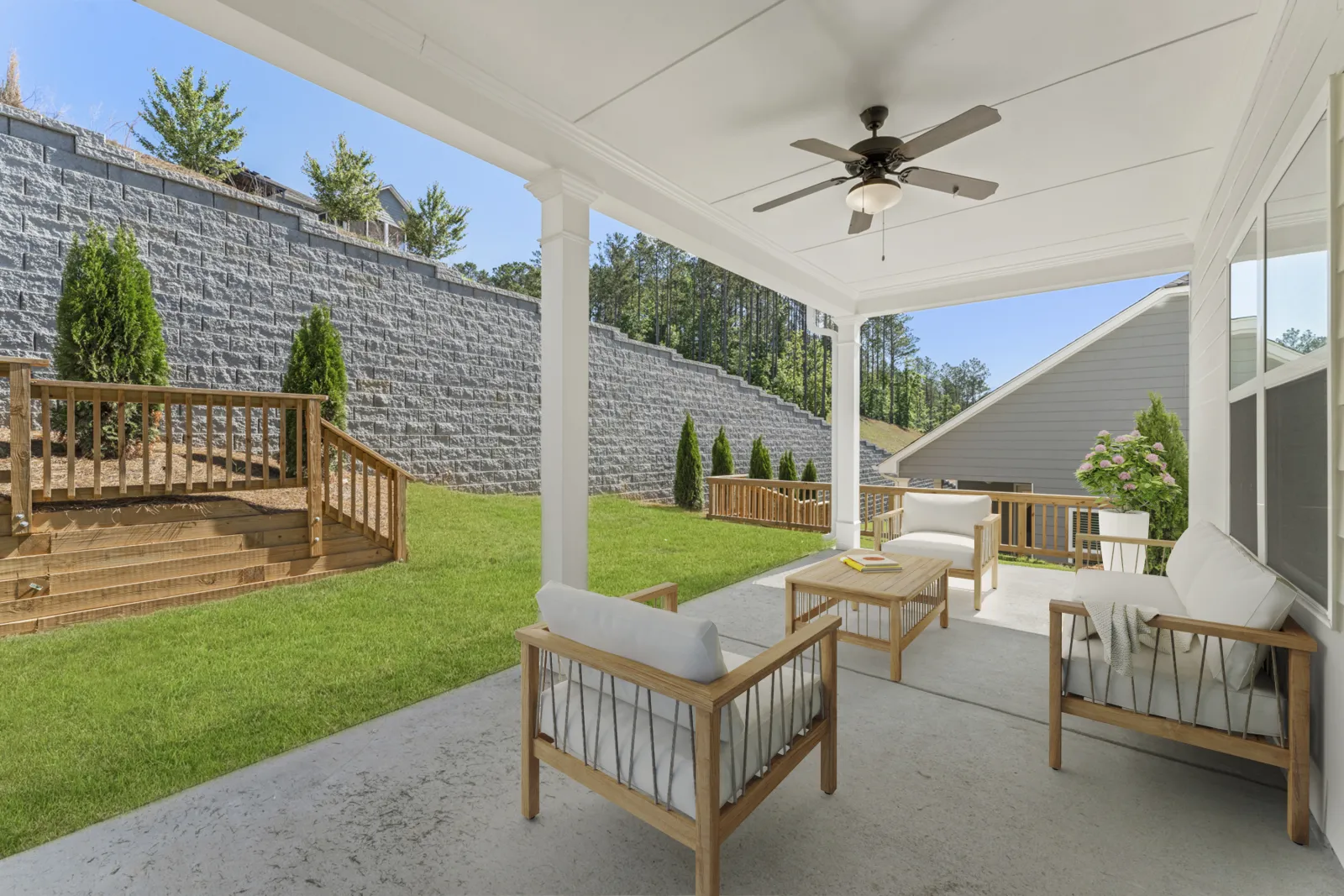 a house with a patio and a large stone wall