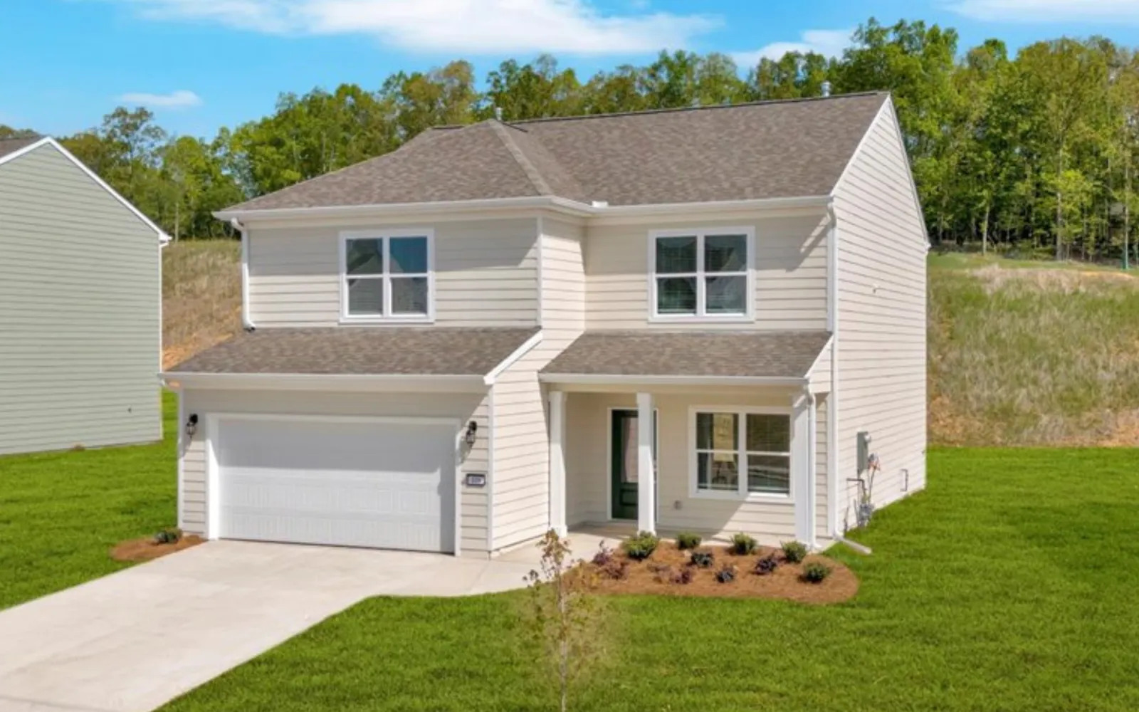 Modern two-story house with white siding, attached garage, front porch, and neatly landscaped lawn in suburban area