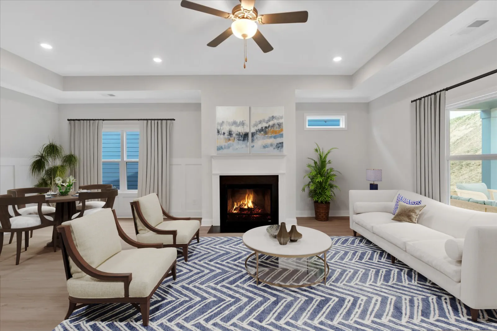 Bright modern living room with white sofa, fireplace, armchairs, round coffee table, and blue patterned rug.