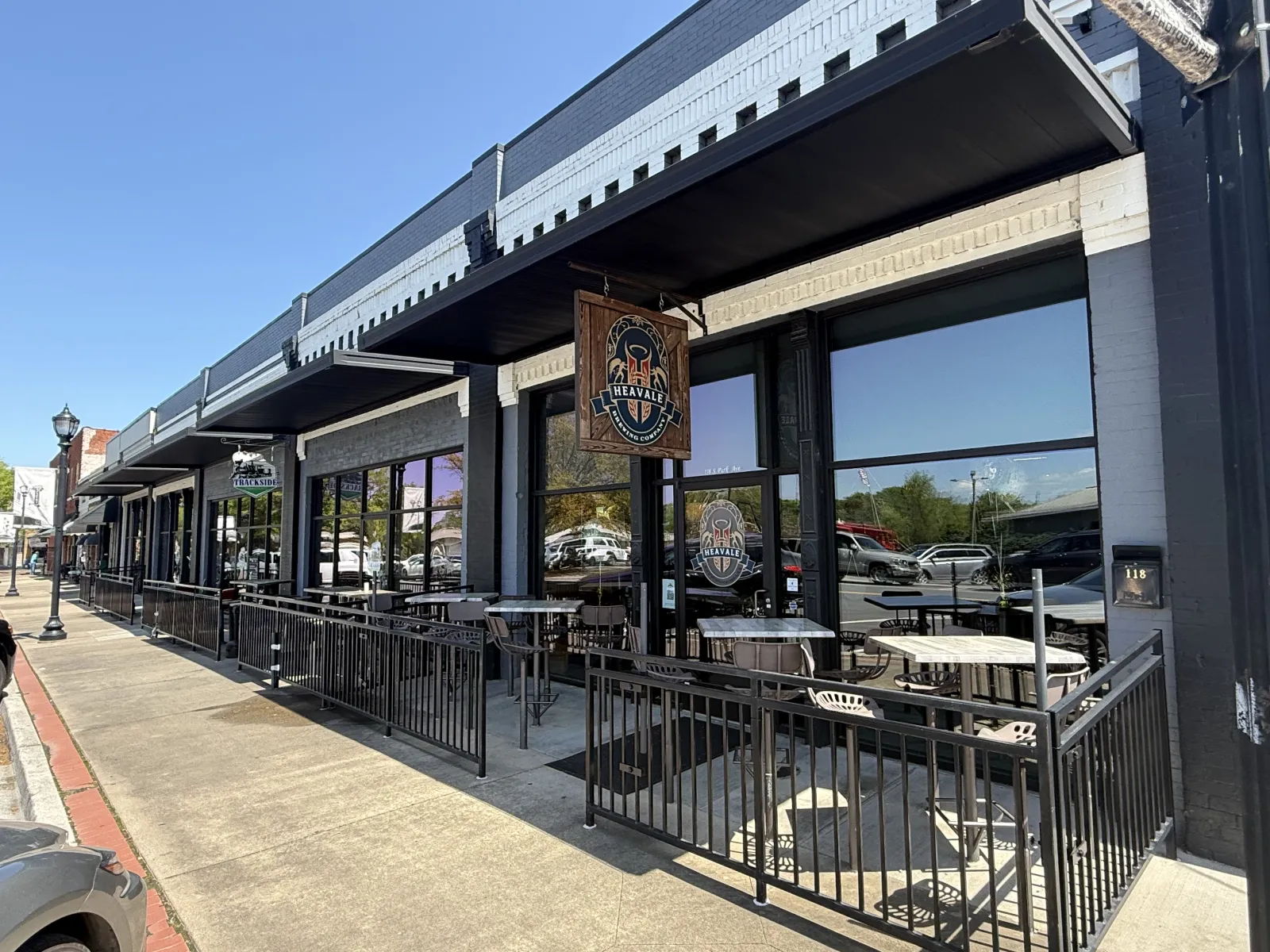 Outdoor patio seating with metal tables and chairs at Heavalle Brewing Company on a sunny day.