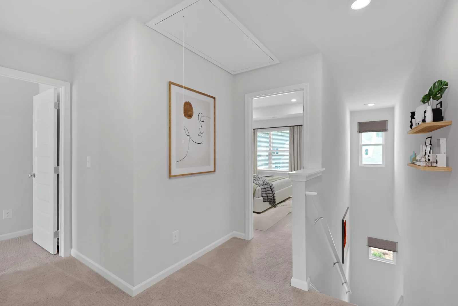 Bright and modern hallway with art, shelves, and cozy room views.