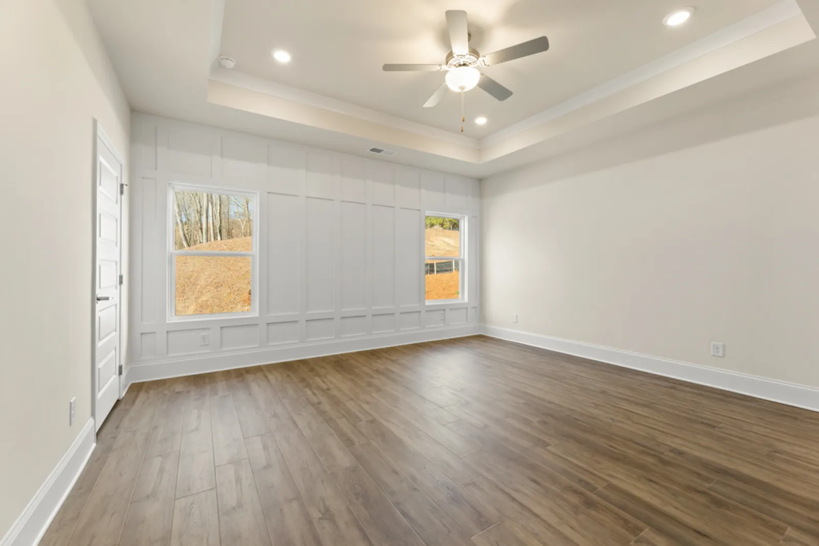 a room with a wood floor and a ceiling fan