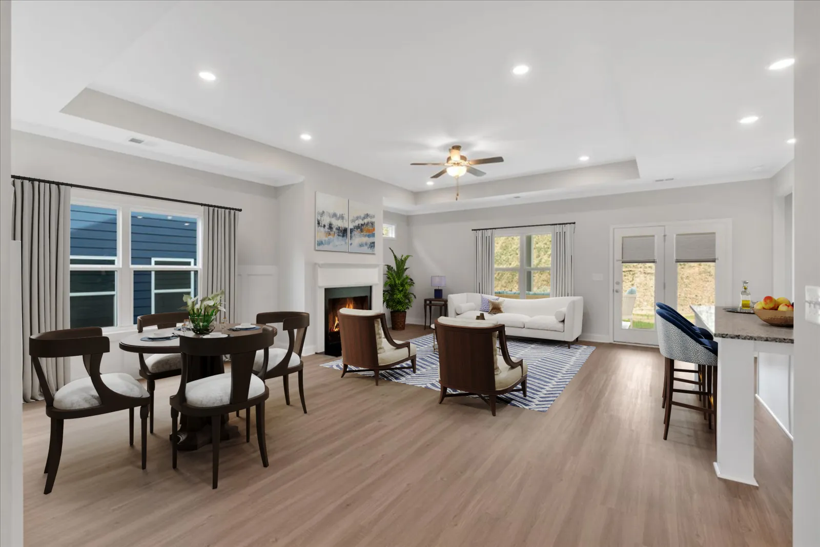 Open concept living and dining area with modern furniture, hardwood floors, ceiling fan, and fireplace in neutral tones.