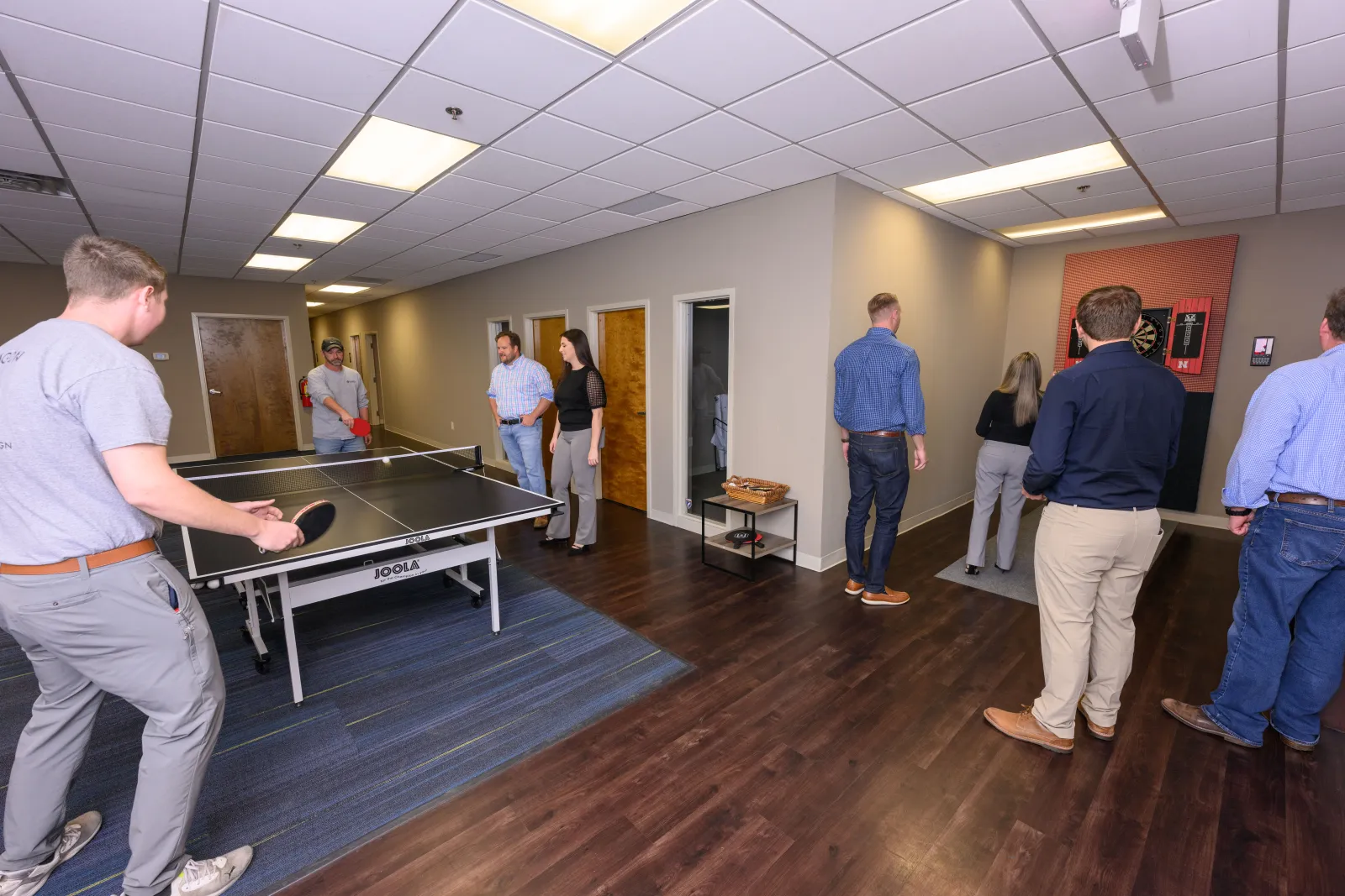 a group of people playing ping pong in a room