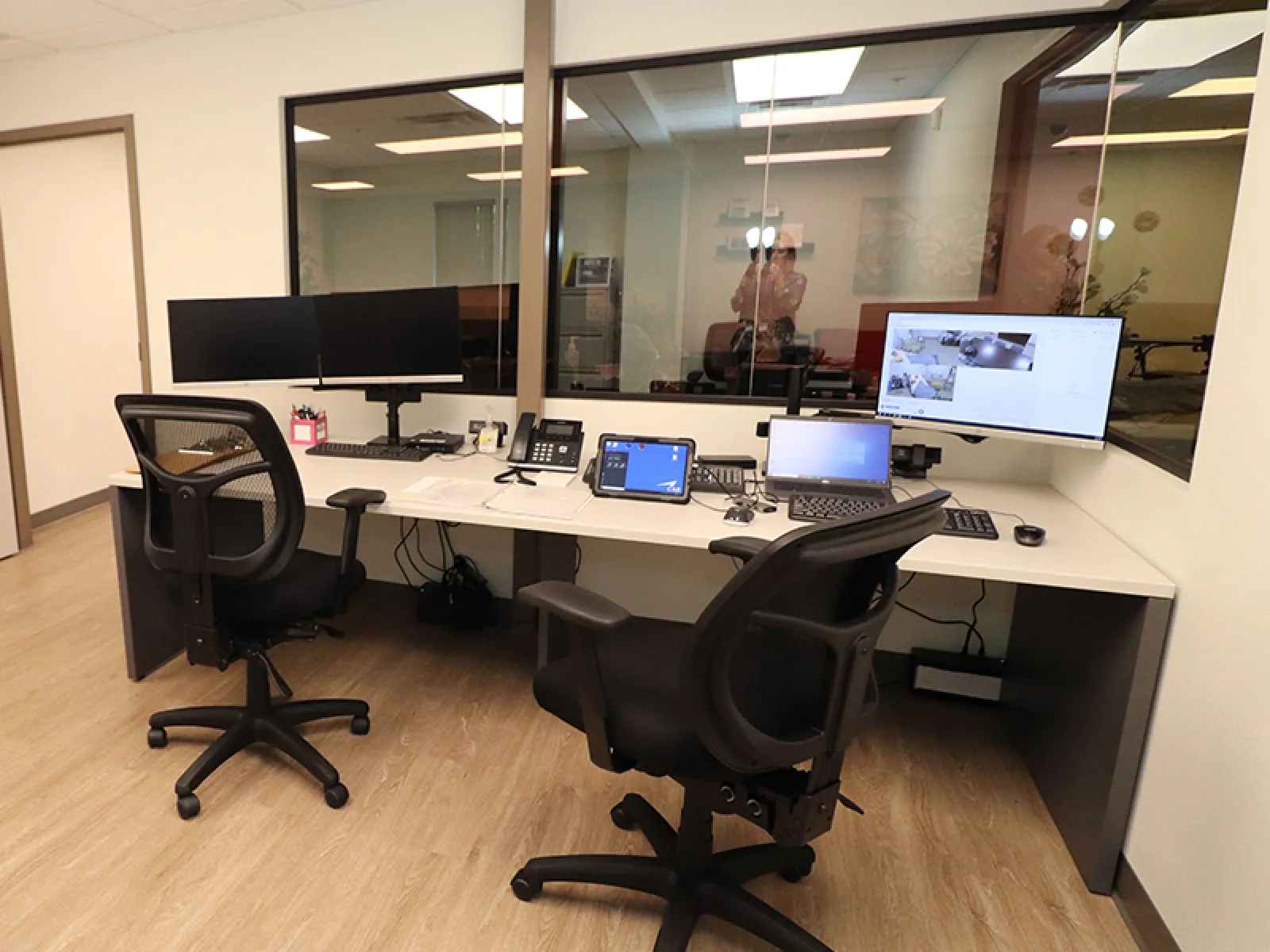 a desk with a chair and computers