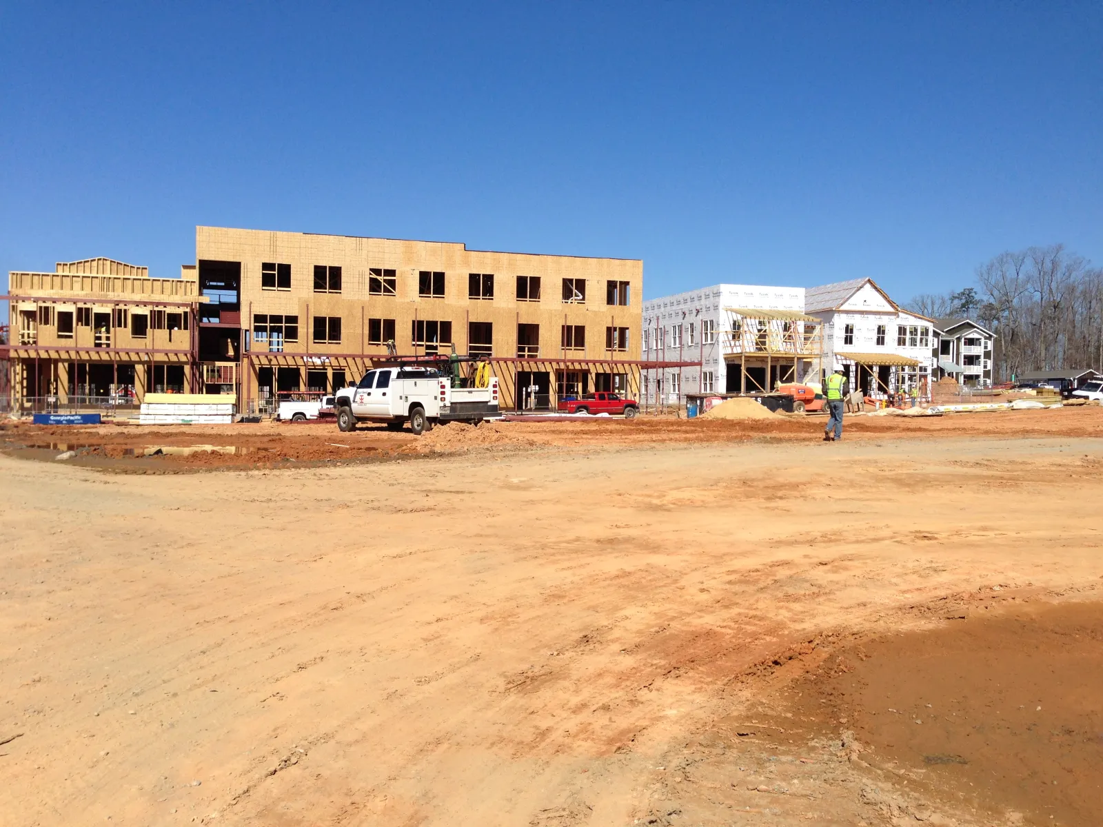 a dirt lot with a few buildings