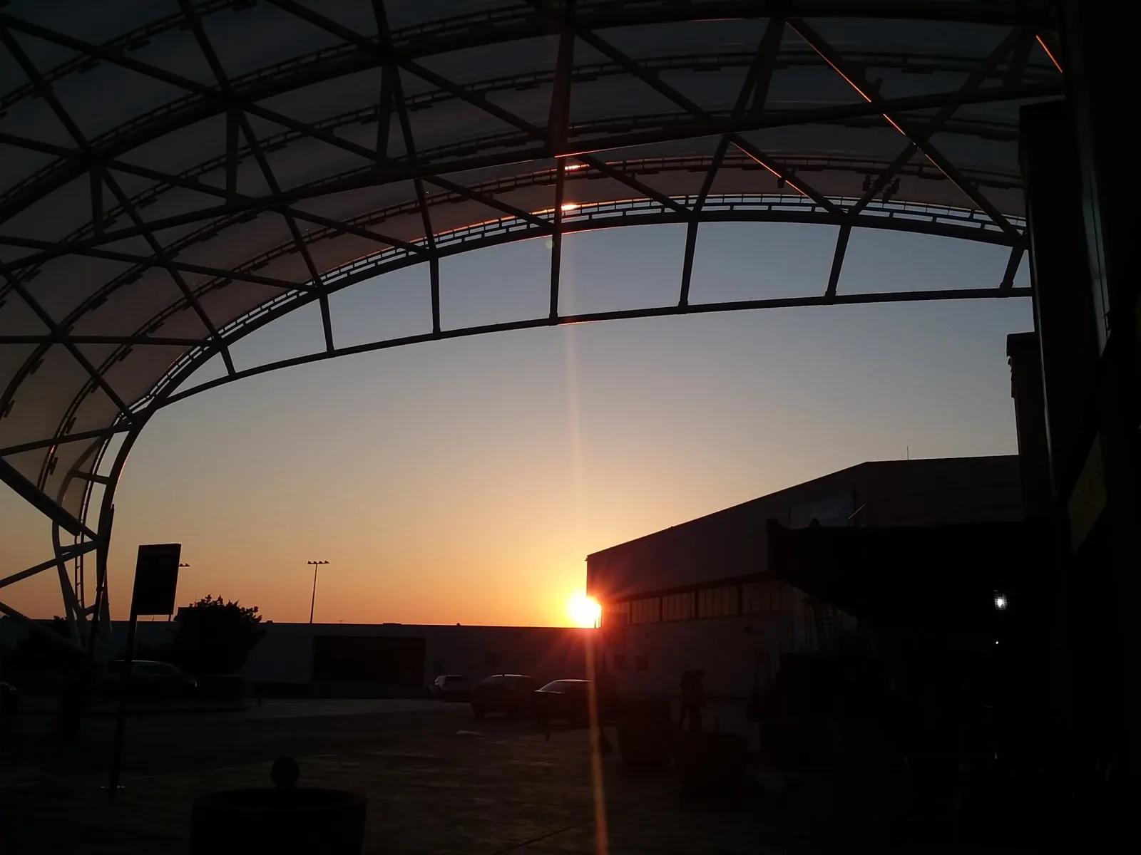 a large glass roof with a sunset