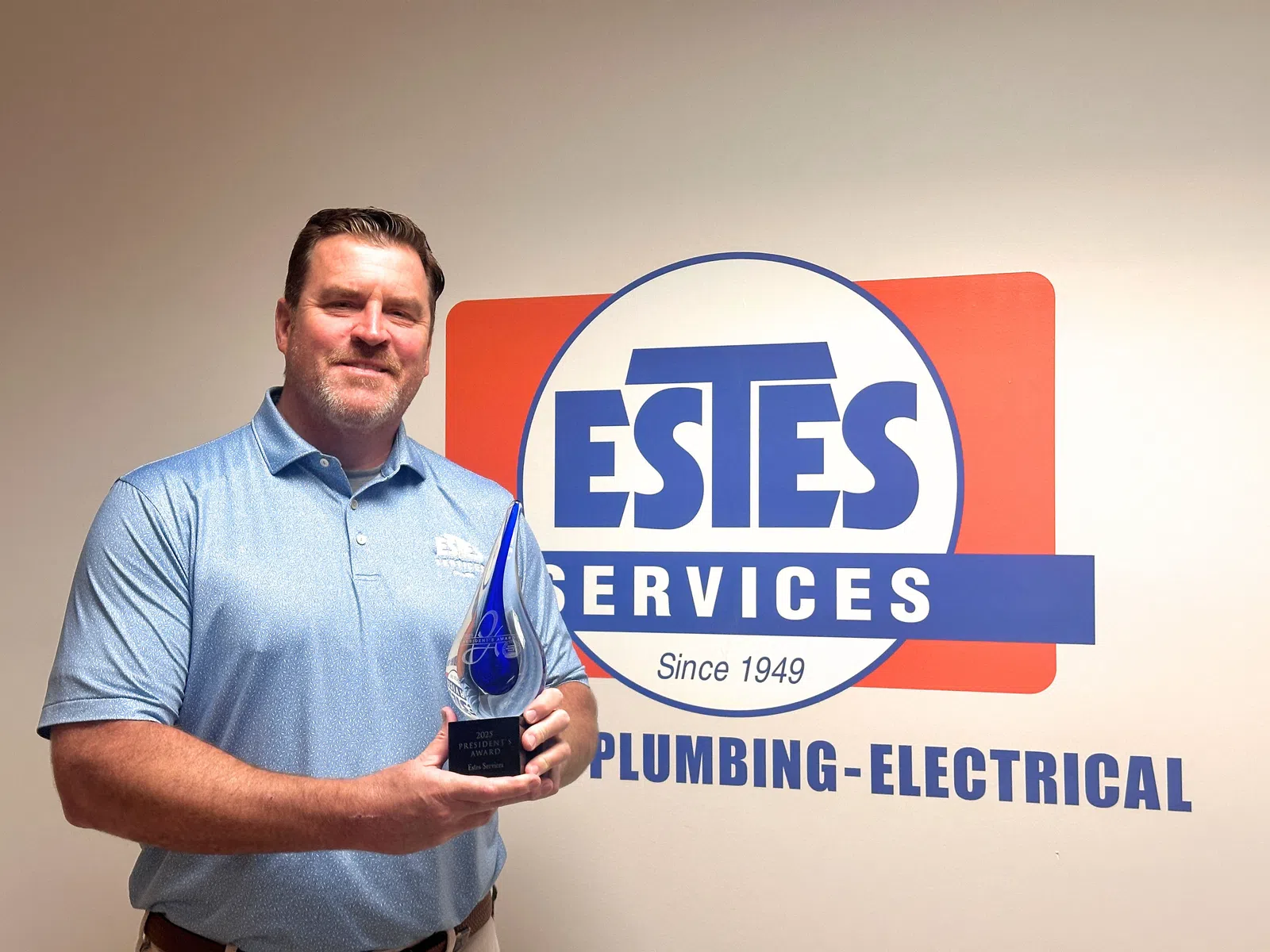 Brian Estes, President of Estes Services, holding the 15th President's Award from Carrier