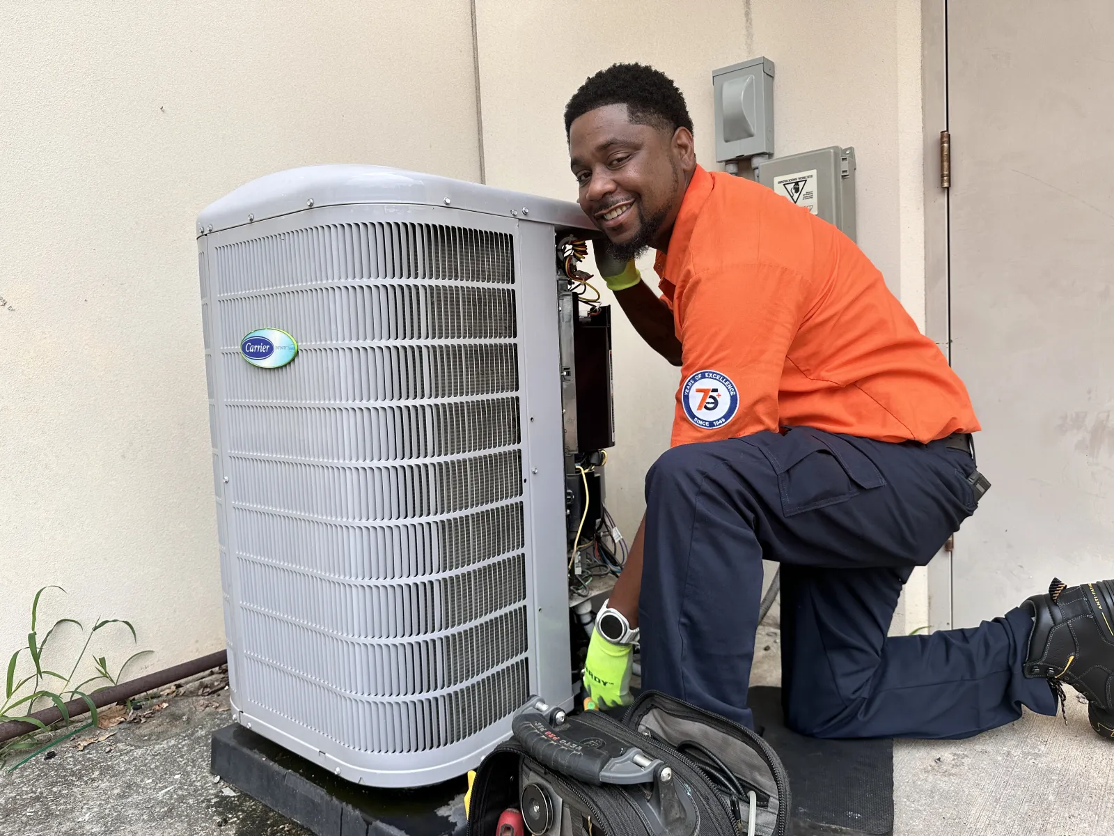 Estes Heating and Air Technician close to a Carrier AC Unit