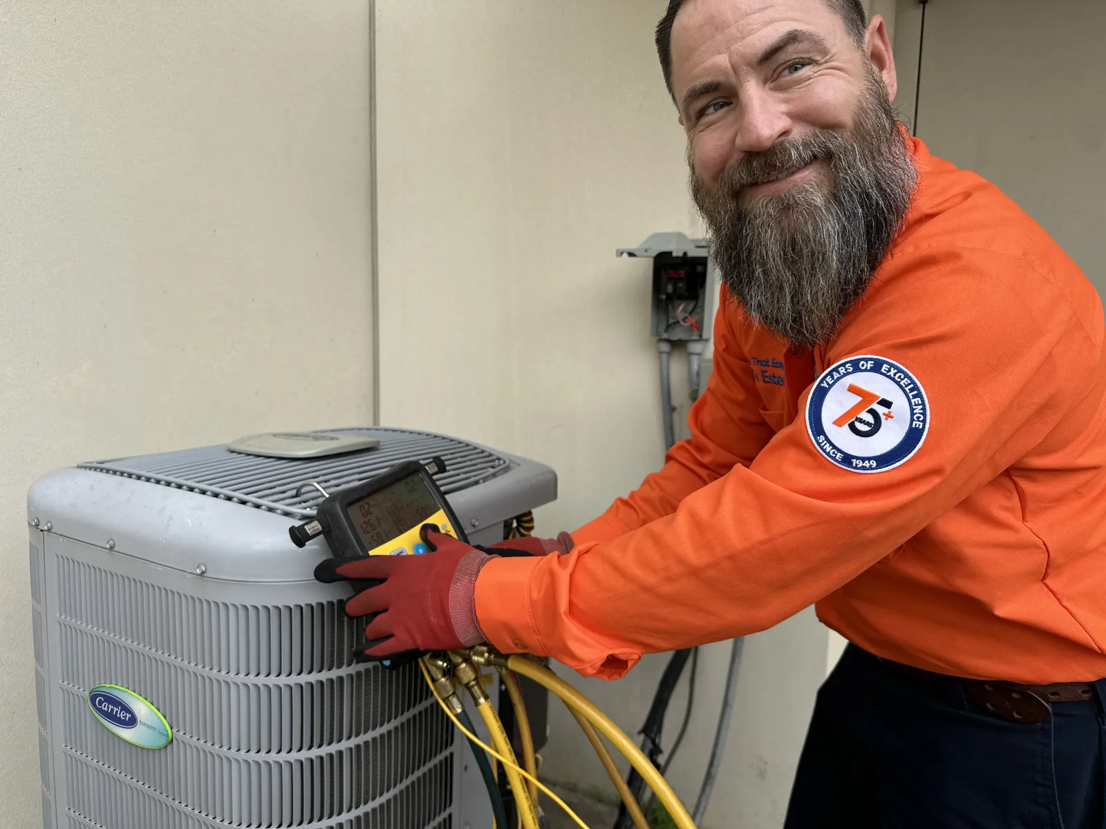 Estes Services Tech smiling while he is fixing an AC