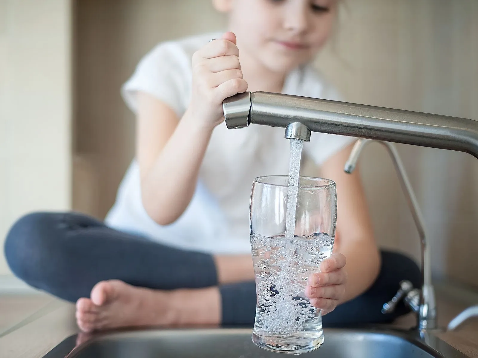 Girl enjoying water filtration installed by Estes Services