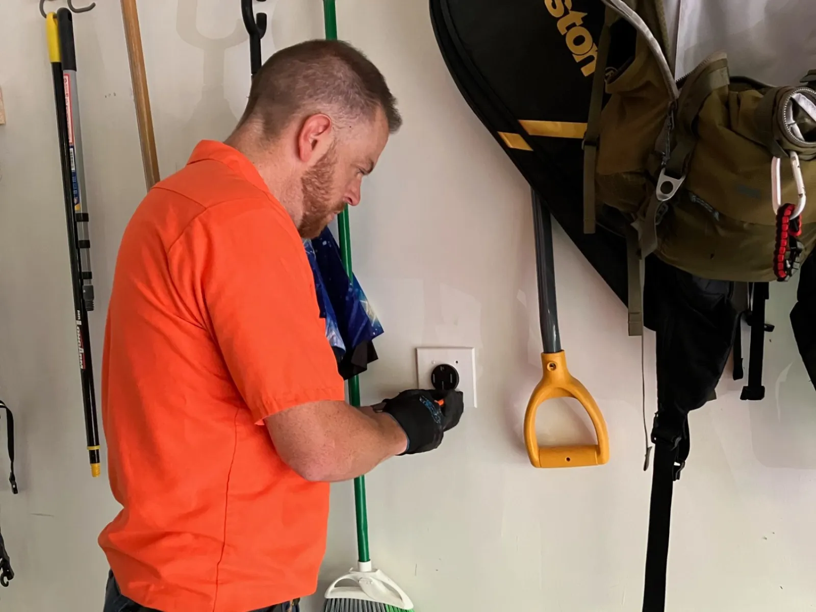 Estes Electrician in orange uniform installing a EV Charger