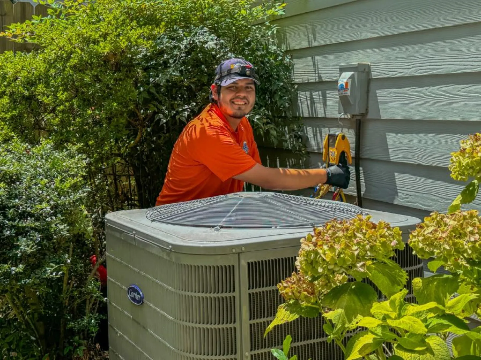 Matt Reyes, Estes HVAC Pro behind a Carrier unit