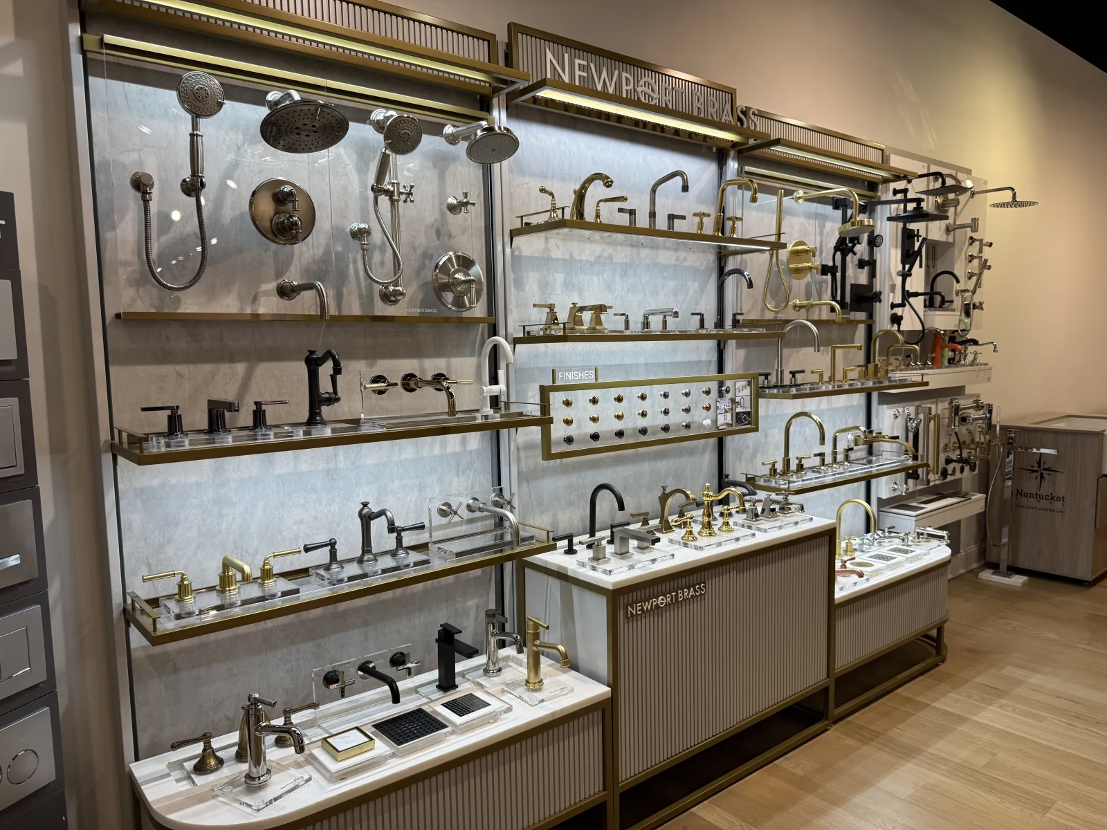 Display of various bathroom and kitchen faucets and shower heads in a showroom with modern design.